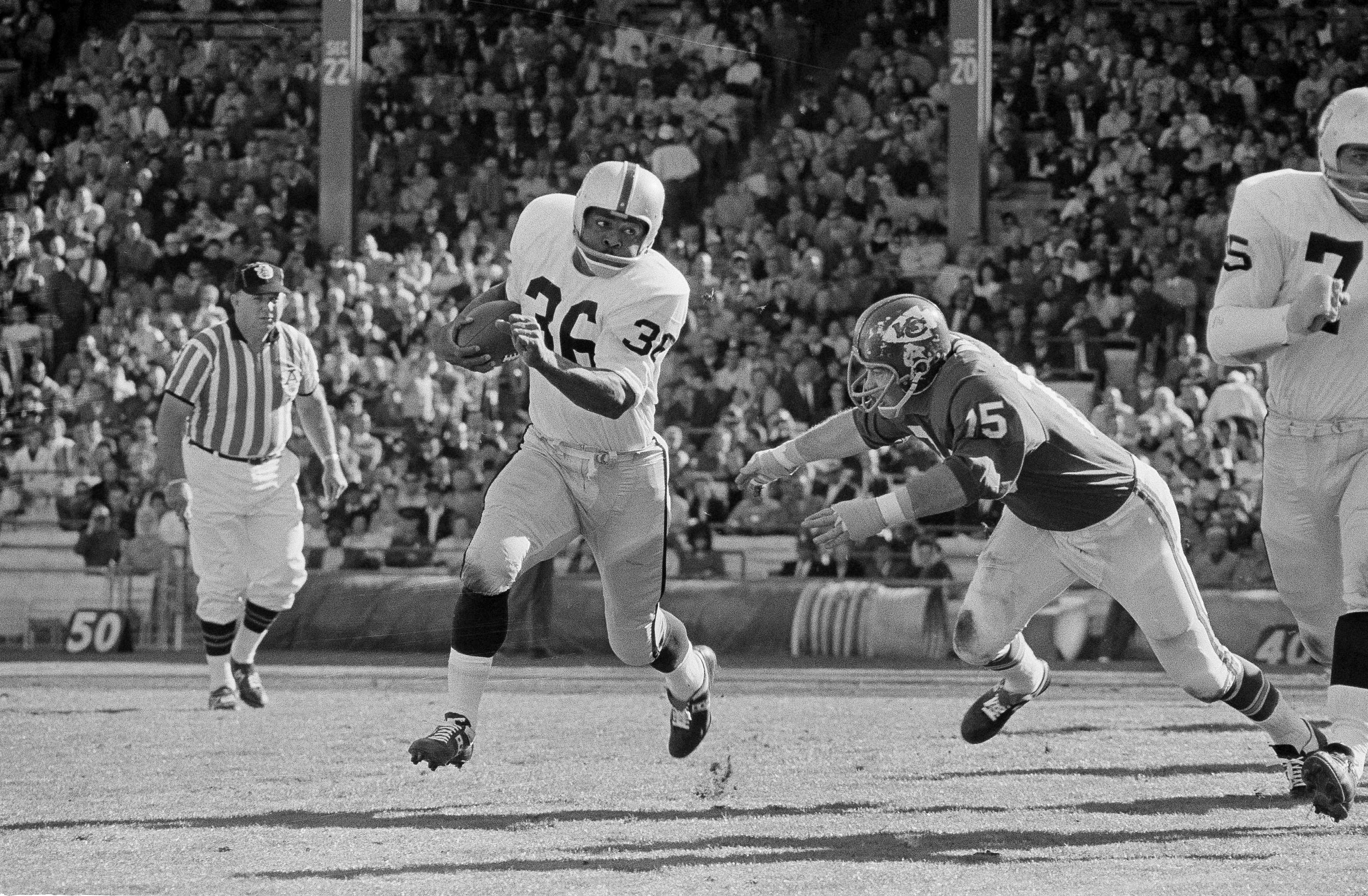 Clem Daniels (36) of the Oakland Raiders races around the right side of his line as Jerry Mays, right, of the Kansas City Chiefs moves in for the tackle, in Kansas City, Mo., Oct. 31, 1965. The Chiefs won 14-7. (William P. Straeter—AP)