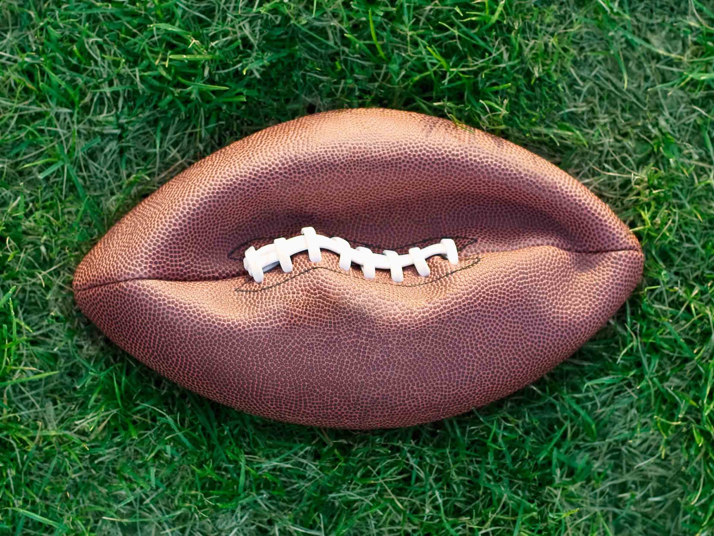 Deflated American football on grass