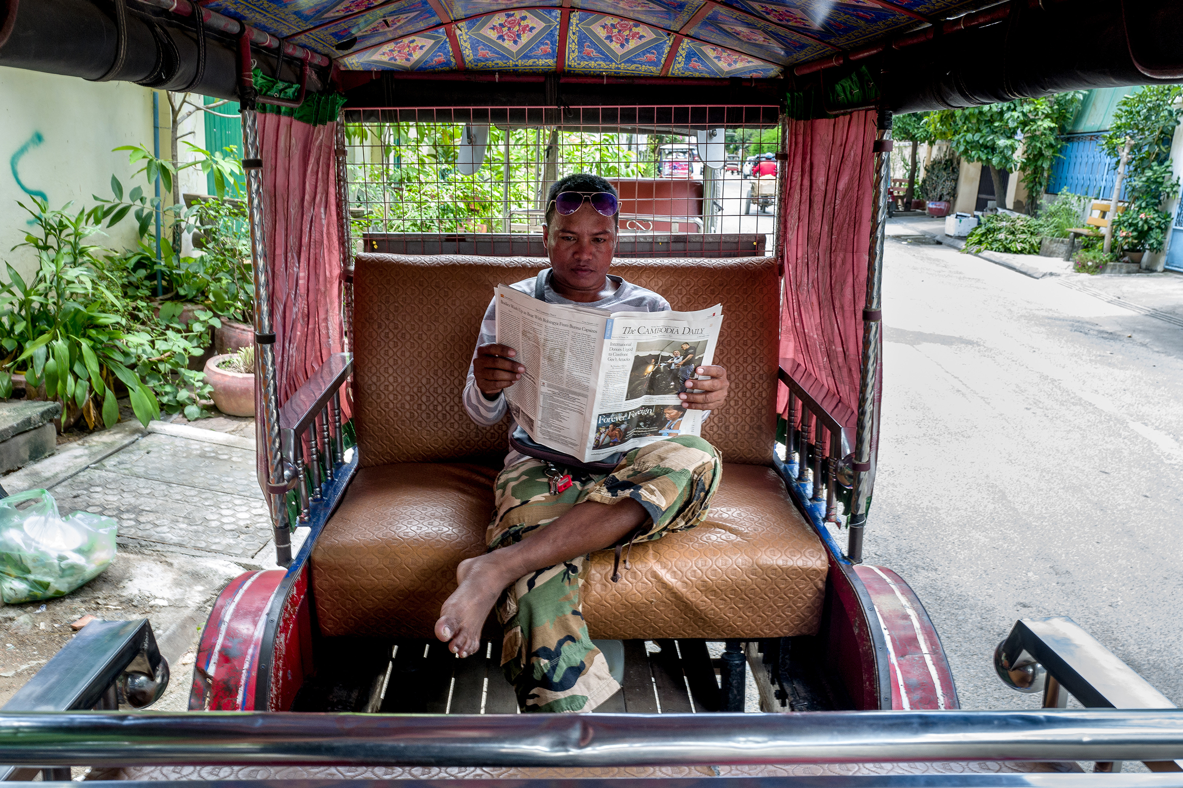 Yan Vivol, a tuk-tuk driver, reads The Cambodia Daily in Phnom Penh on Sept. 1, 2017. (Omar Havana—The New York Times/Redux)