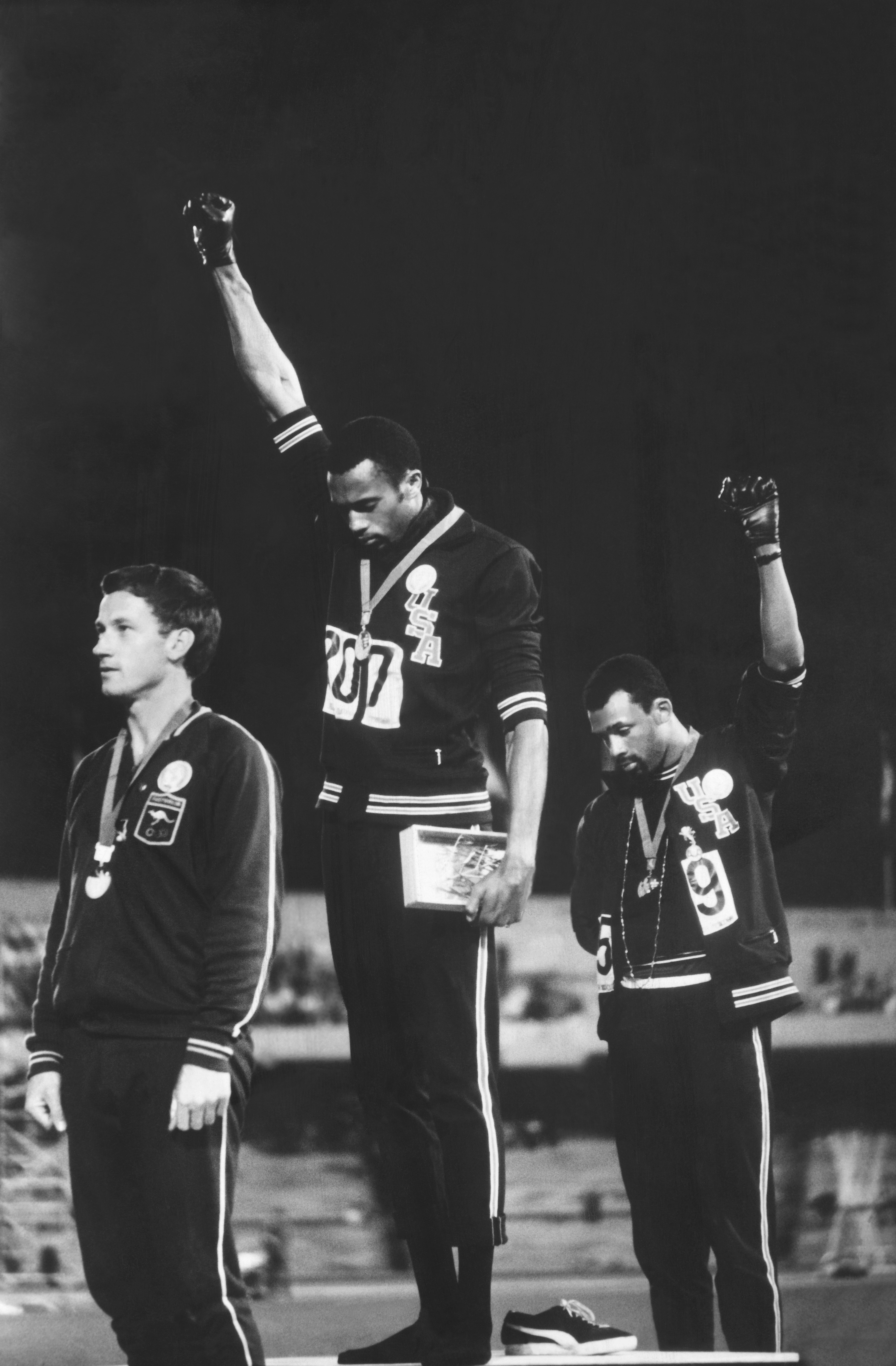 American track and field athletes Tommie Smith (C) and John Carlos (R), first and third place winners in the 200-meter race, protest with the Black Power salute as they stand on the winner's podium at the Summer Olympic games in Mexico City on October 19, 1968. (John Dominis/The LIFE Picture Collection—Getty Images)
