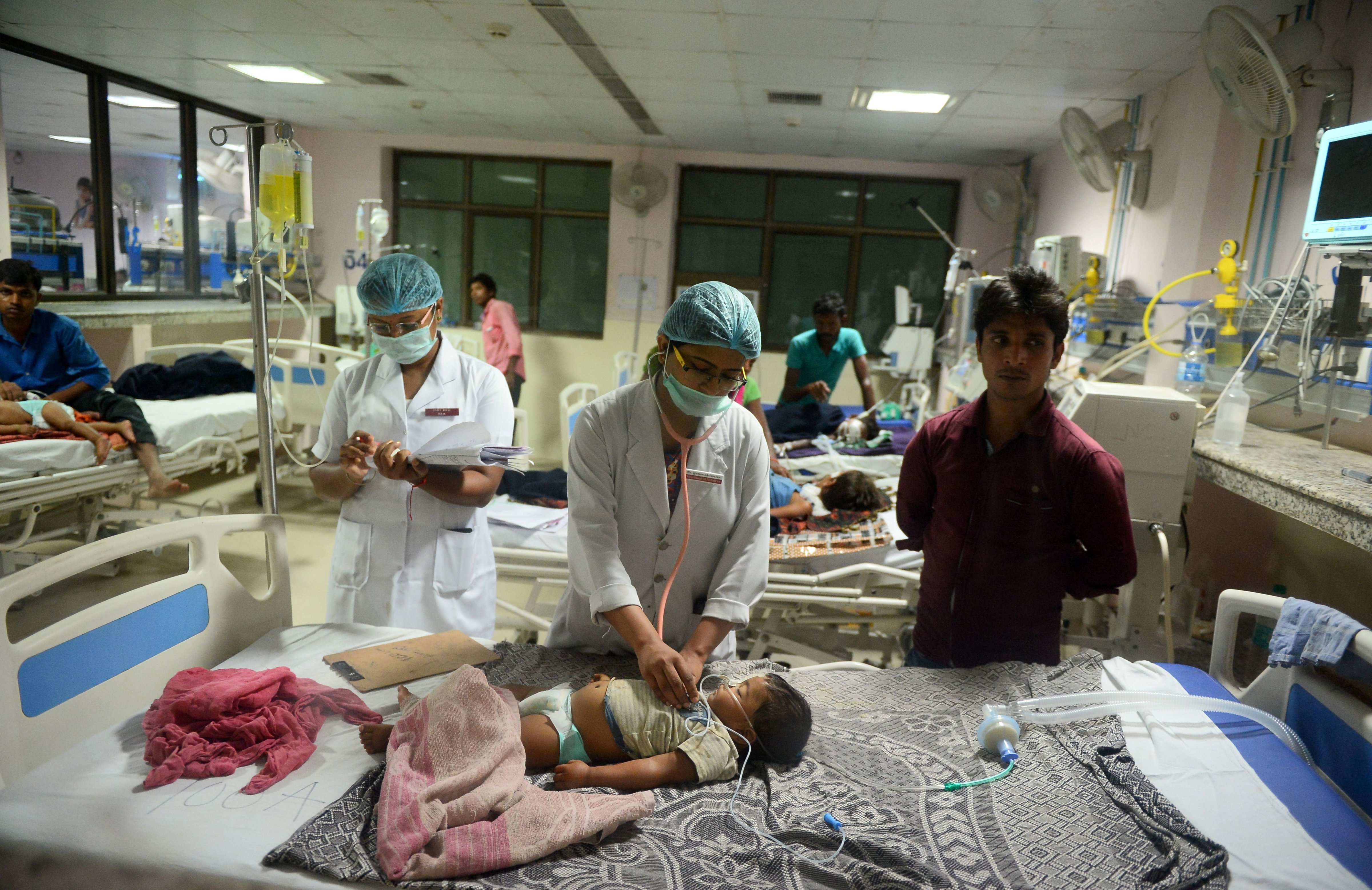 Indian medical staff attend to a child admitted in the Encephalitis ward at The Baba Raghav Das Hospital in Gorakhpur, Uttar Pradesh, on August 12, 2017. (Sanjay Kanojia—AFP/Getty Images)