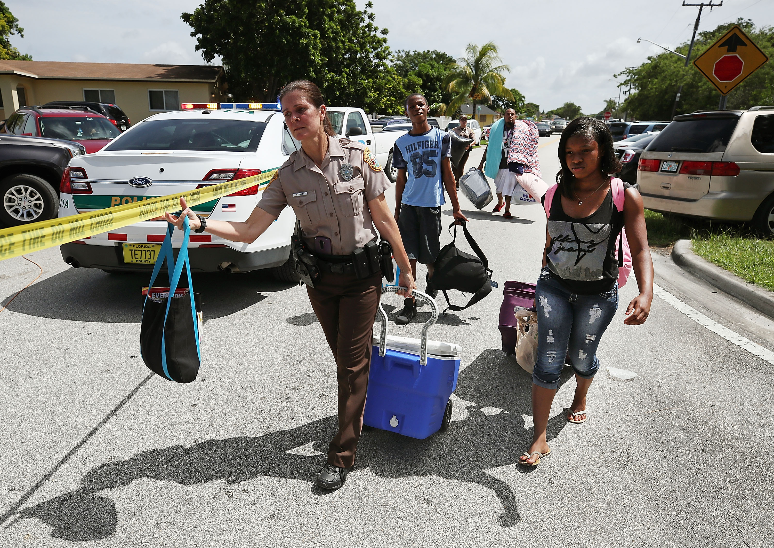 Officer Kerensa Smith with the Miami Dade Police Department helps evacuees move to a bus to take them to a shelter as Hurricane Irma approaches Miami on September 8, 2017. (Mark Wilson—Getty Images)