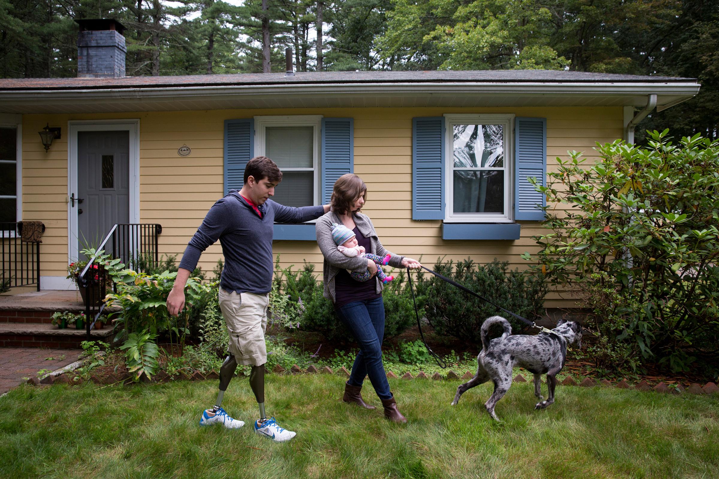 Jeff Bauman, who lost both of his legs in the Boston Marathon bombing, with Erin Hurley and their 2-month-old daughter, Nora, and dog, Bandit, in Boston, Sept. 16, 2014.