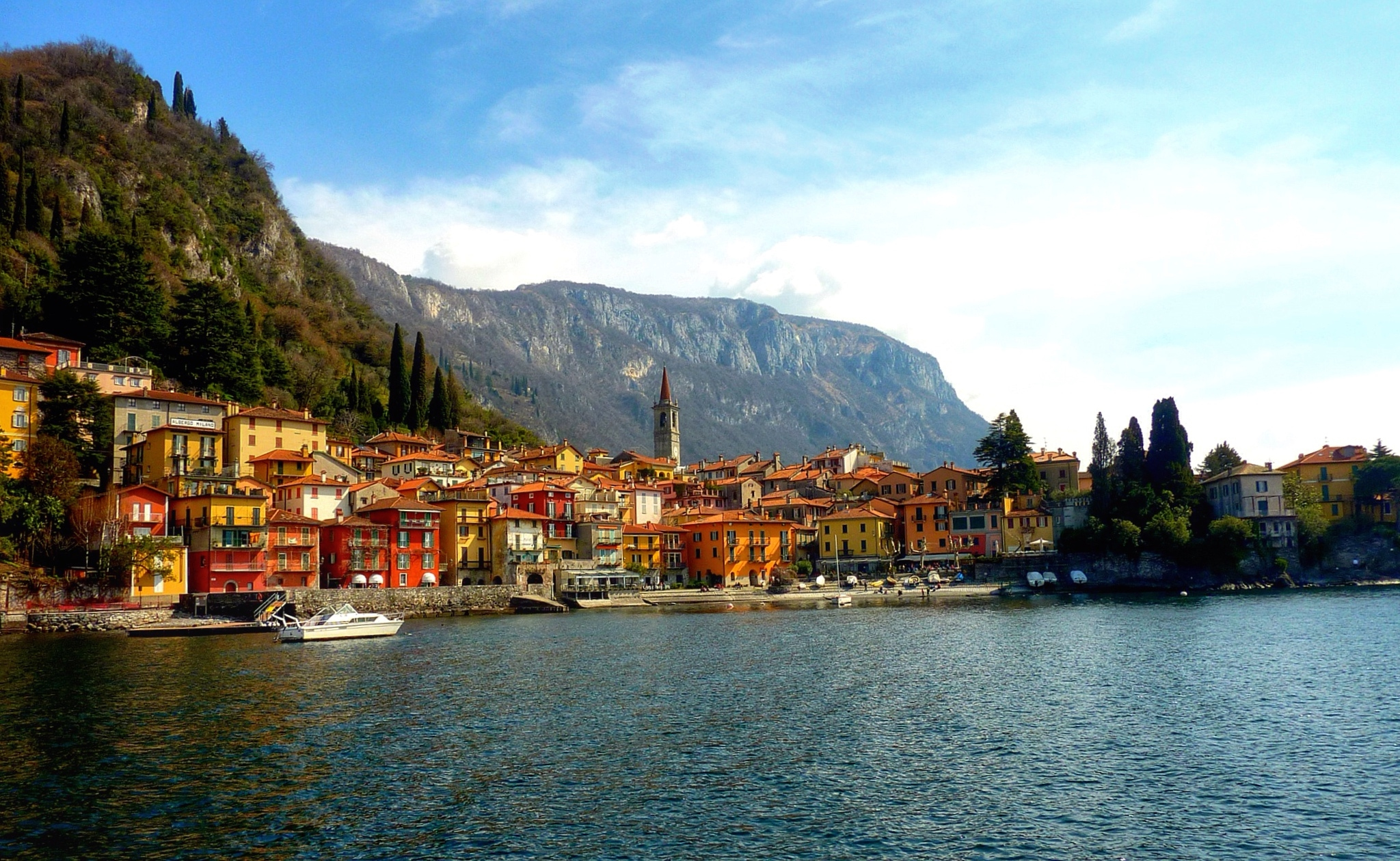 Village On Shores Of Lake Como With Mountains In The Background