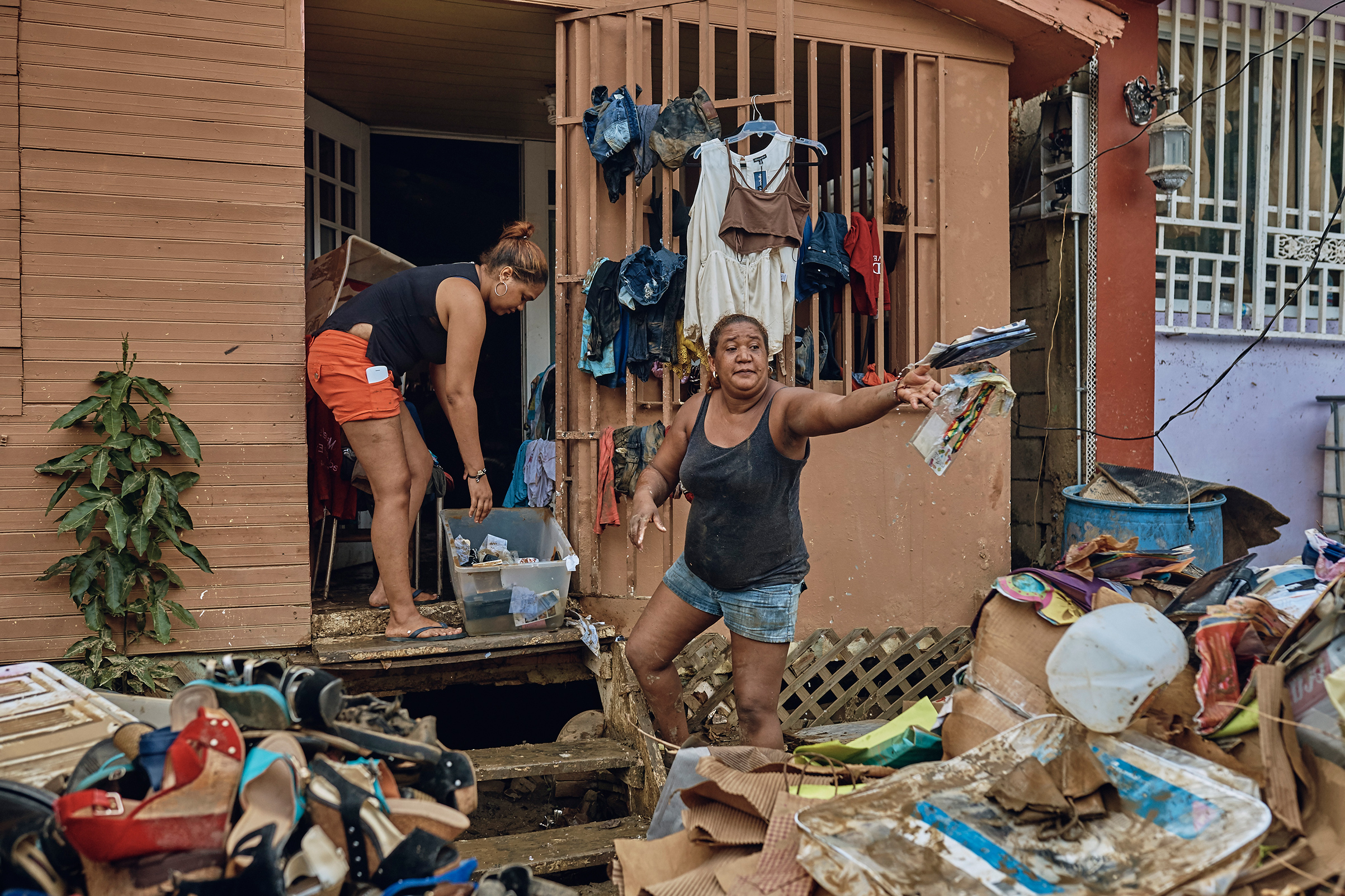 Belkis, 42, right, and her daughter remove damaged belongings from their flooded home in San Isidro, Puerto Rico, on Sept. 28, 2017. (Andres Kudacki for TIME)