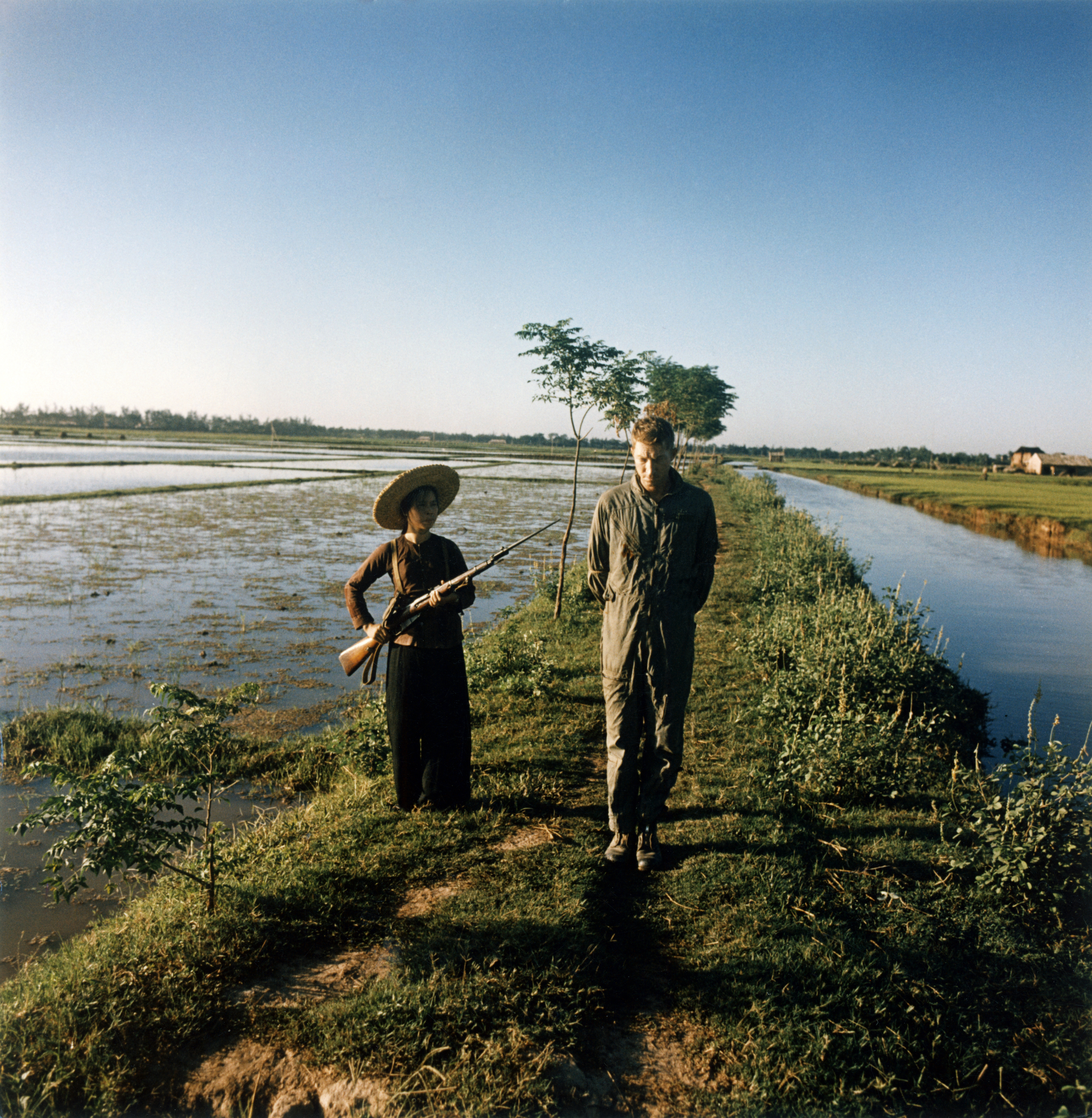 Captured U.S. pilot major Dewey Waddell is guarded by a militiawoman with a gun and a bayonet on a rice field. Vietnam, 1967. (ullstein bild via Getty Images)