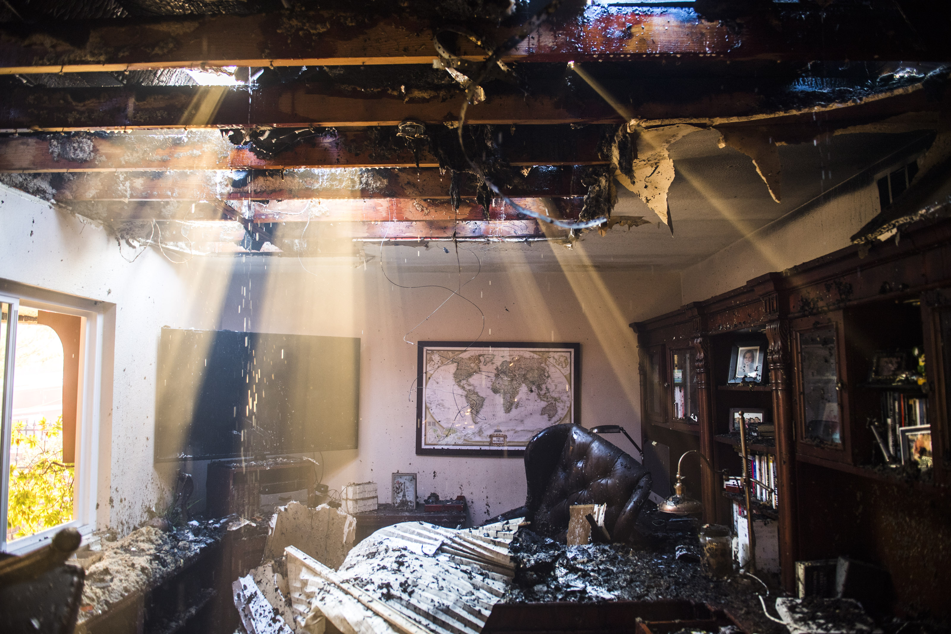 Smoke and water stream through the roof of a damaged home in Anaheim Hills on Oct. 9 (Stuart Palley—LA Times/Getty Images)