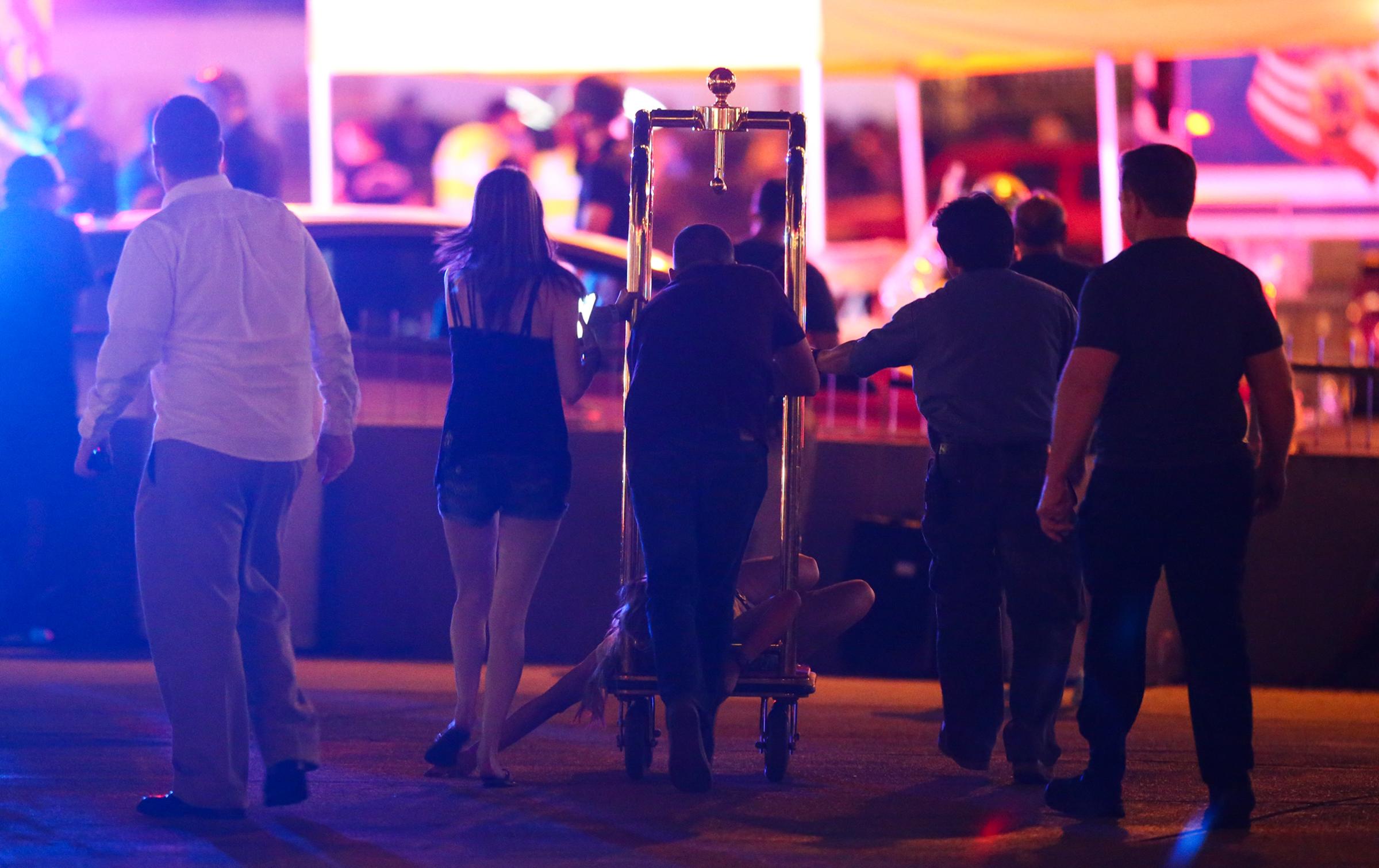 A wounded woman is transported outside the Tropicana during an active shooter situation on the Las Vegas Strip on Oct. 1, 2017.