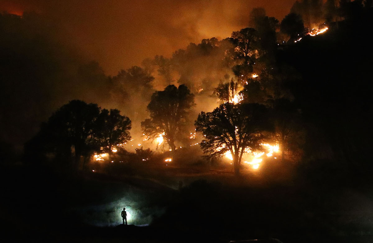 A Cal Fire firefighter is silhouetted by his headlamp as he monitors a backfire while battling the Rocky Fire on Aug. 3, 2015 near Clearlake, Calif. (Justin Sullivan—Getty Images)