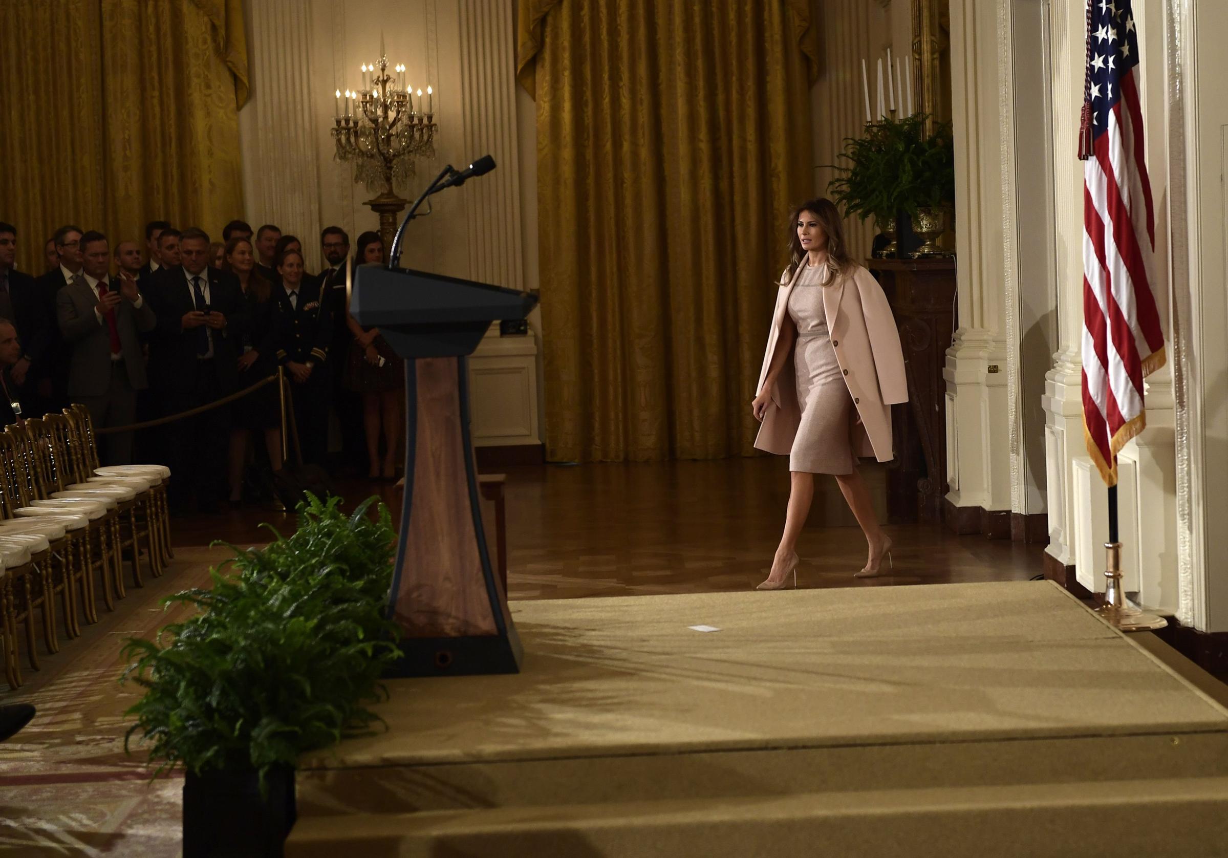 First lady Melania Trump wearing a beige dress and a pale pink coat arrives for an event Oct. 12, 2017 at the White House in Washington, DC.