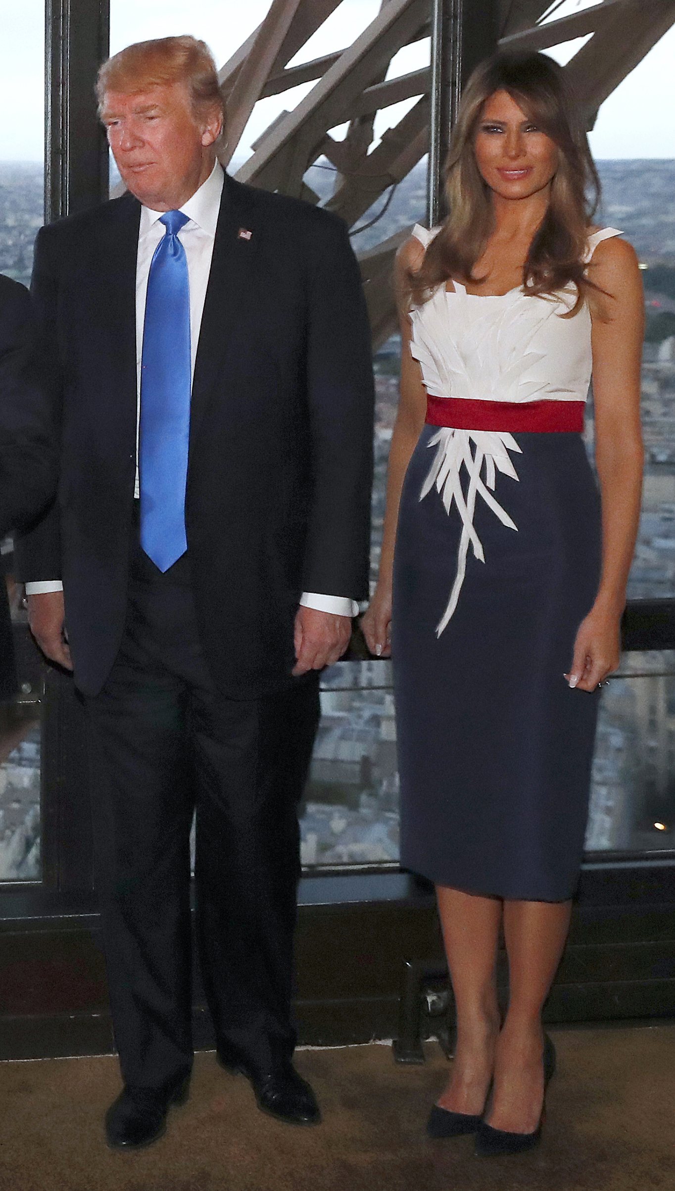 President Donald Trump (L) and First Lady Melania Trump (R) in a dress created by Hervé Pierre, pose upon their arrival for a dinner with French President and his wife, at Le Jules Verne Restaurant on the Eiffel Tower in Paris, on July 13, 2017..