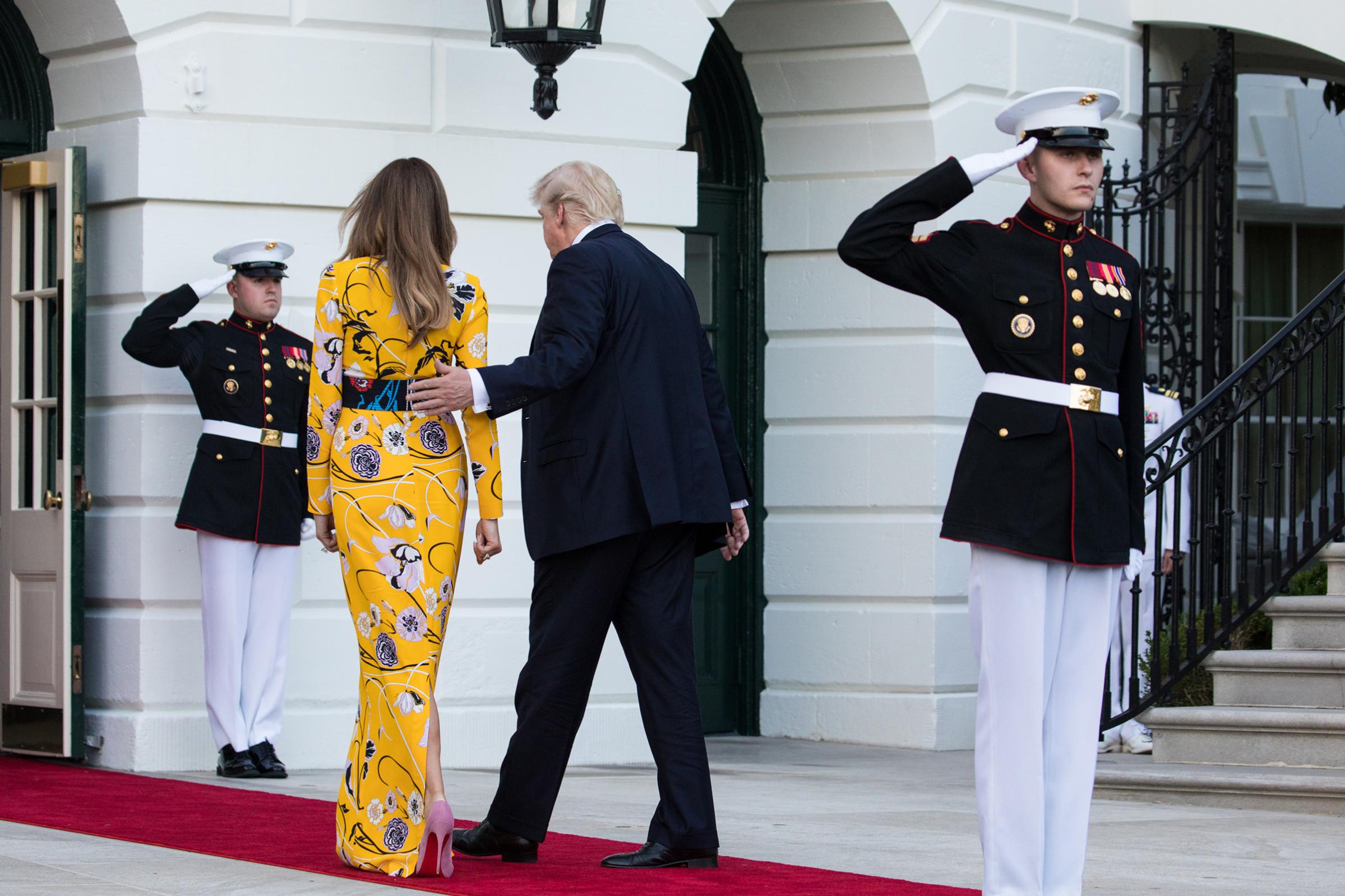First lady Melania Trump wearing a yellow Pucci dress and President Donald Trump head back in to the White House, after the departure of Prime Minister Narendra Modi of India, June 26, 2017.