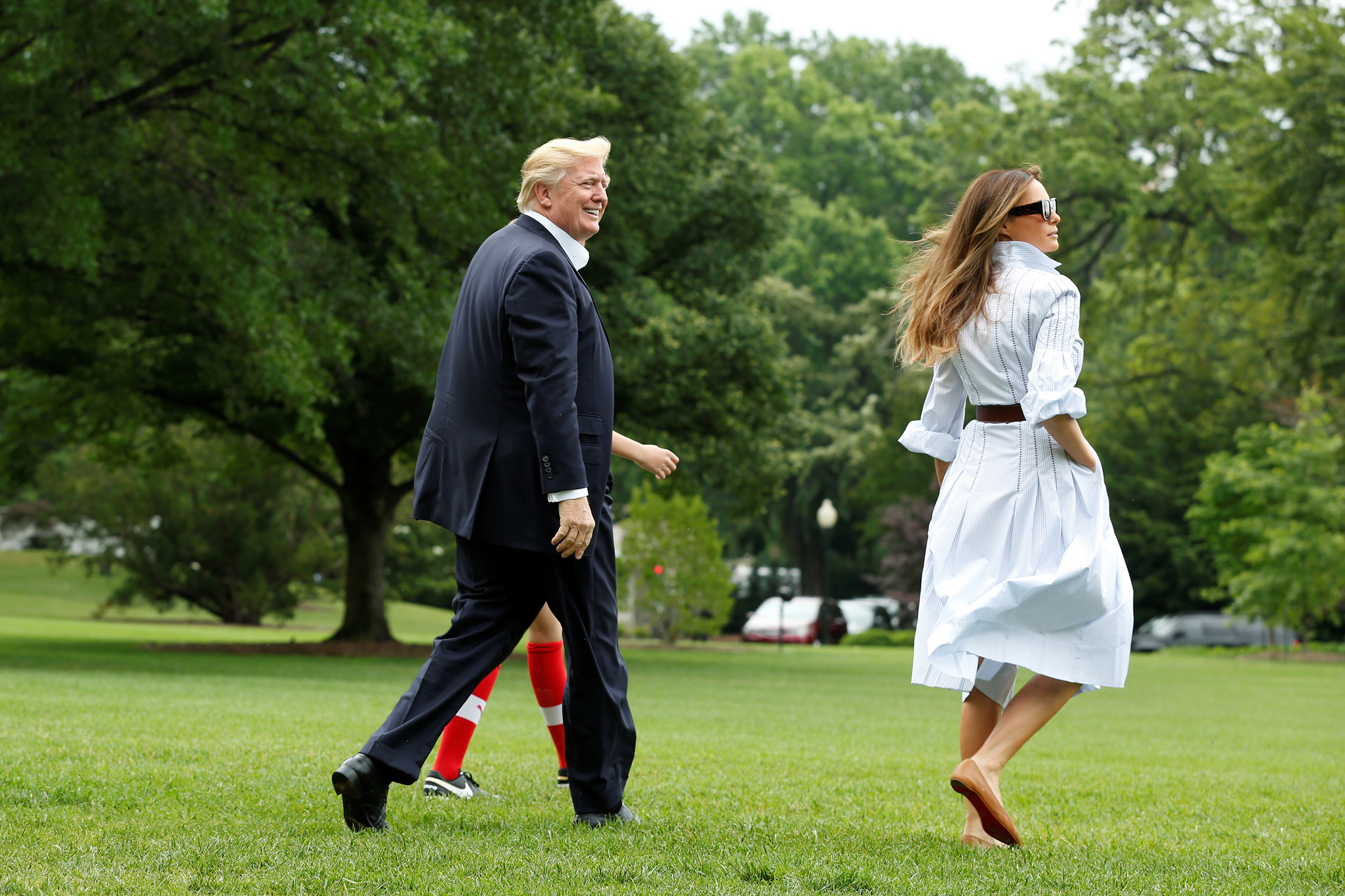 President Donald Trump with first lady Melania wearing a shirt dress by Gabriela Hearst, and their son Barron walk on the South Lawn of the White House in Washington, U.S., before their departure to Camp David, June 17, 2017.