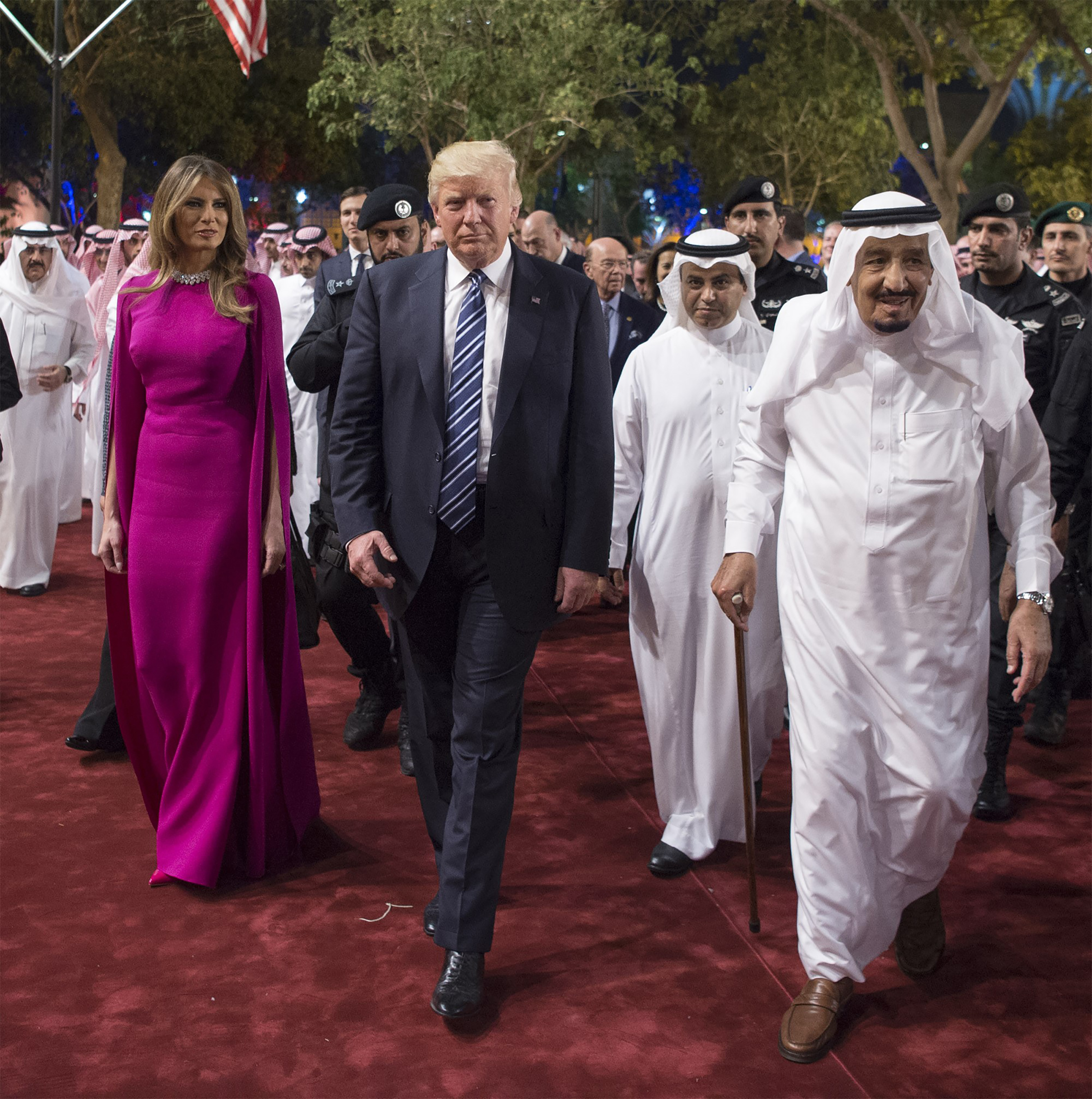 Saudi Arabia's King Salman bin Abdulaziz Al Saud (R) welcomes U.S. President Donald Trump (C)  and first lady Melania Trump wearing magenta Reem Acra gown with cape sleeves, ahead of a dinner given in honour of him at Murabba Palace in Riyadh, Saudi Arabia on May 20, 2017.