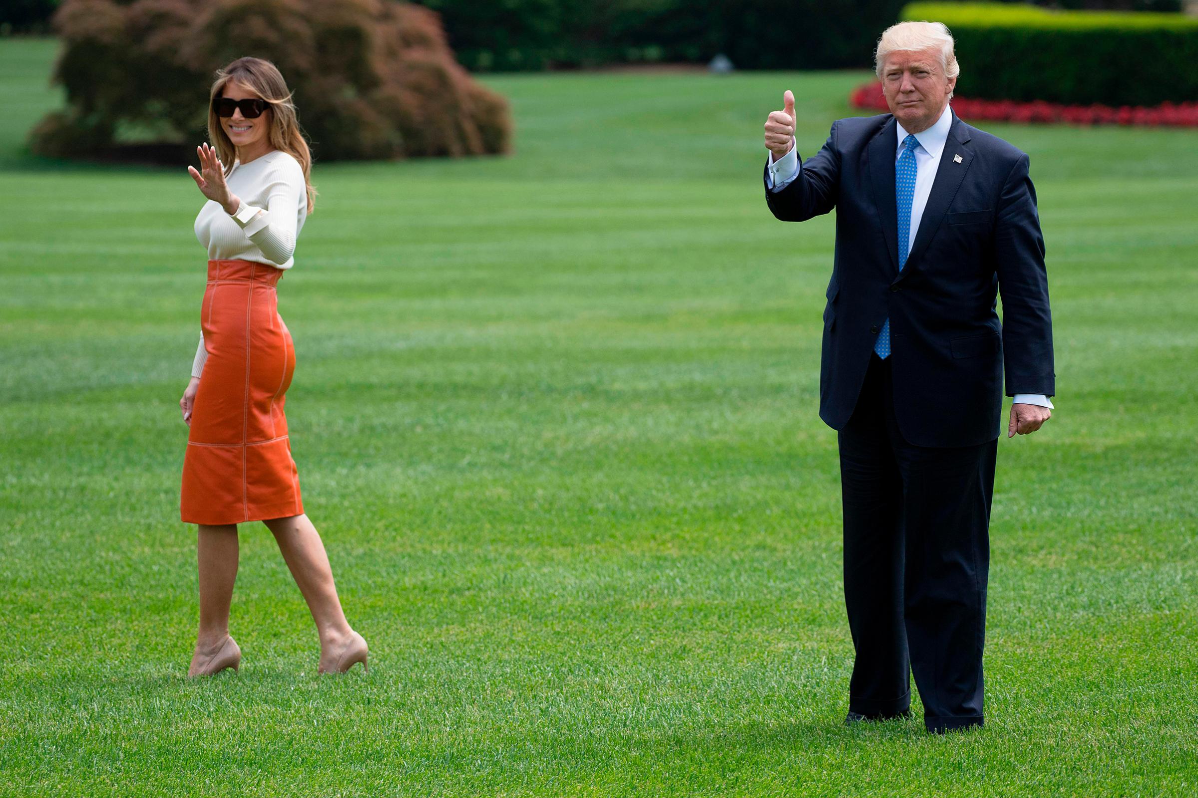 President Donald Trump (R) gives a thumbs up as he and First Lady Melania Trump wearing a Max Mara sweater and Hervé Pierre leather skirt, depart the White House in Washington, DC, May 19, 2017.