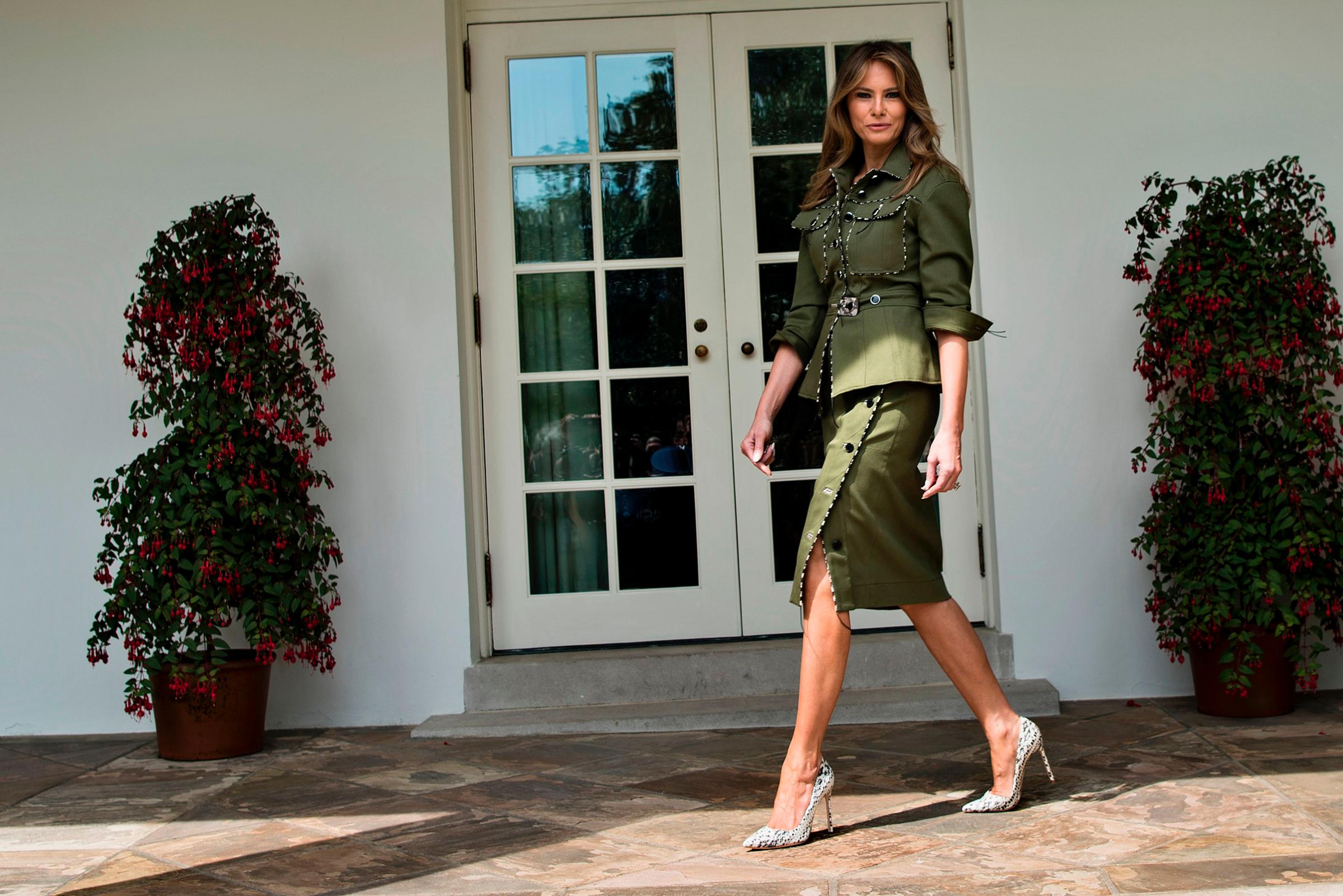 First lady Melania Trump wearing a khaki green, military-look suit by Altuzarra walks past the West Wing of the White House April 27, 2017.