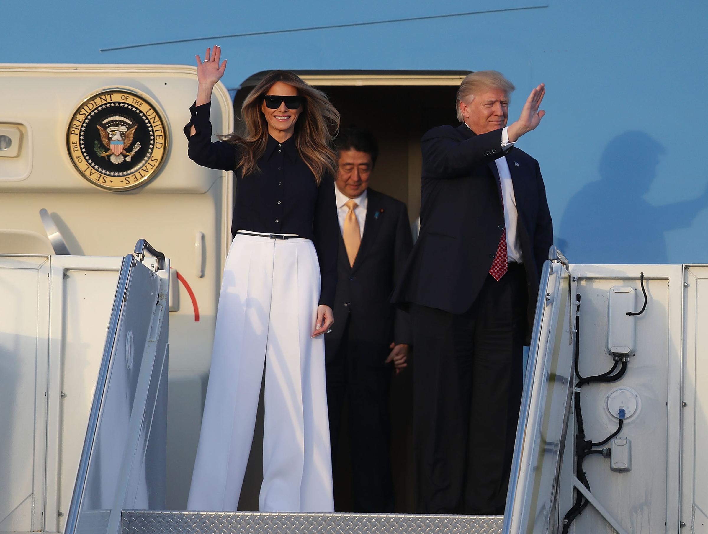 President Donald Trump and first lady Melania Trump , wearing black blouse and white wide-legged pants, arrive with Japanese Prime Minister Shinzo Abe on Air Force One at the Palm Beach International Airport Feb. 10, 2017 in West Palm Beach, Fla.
