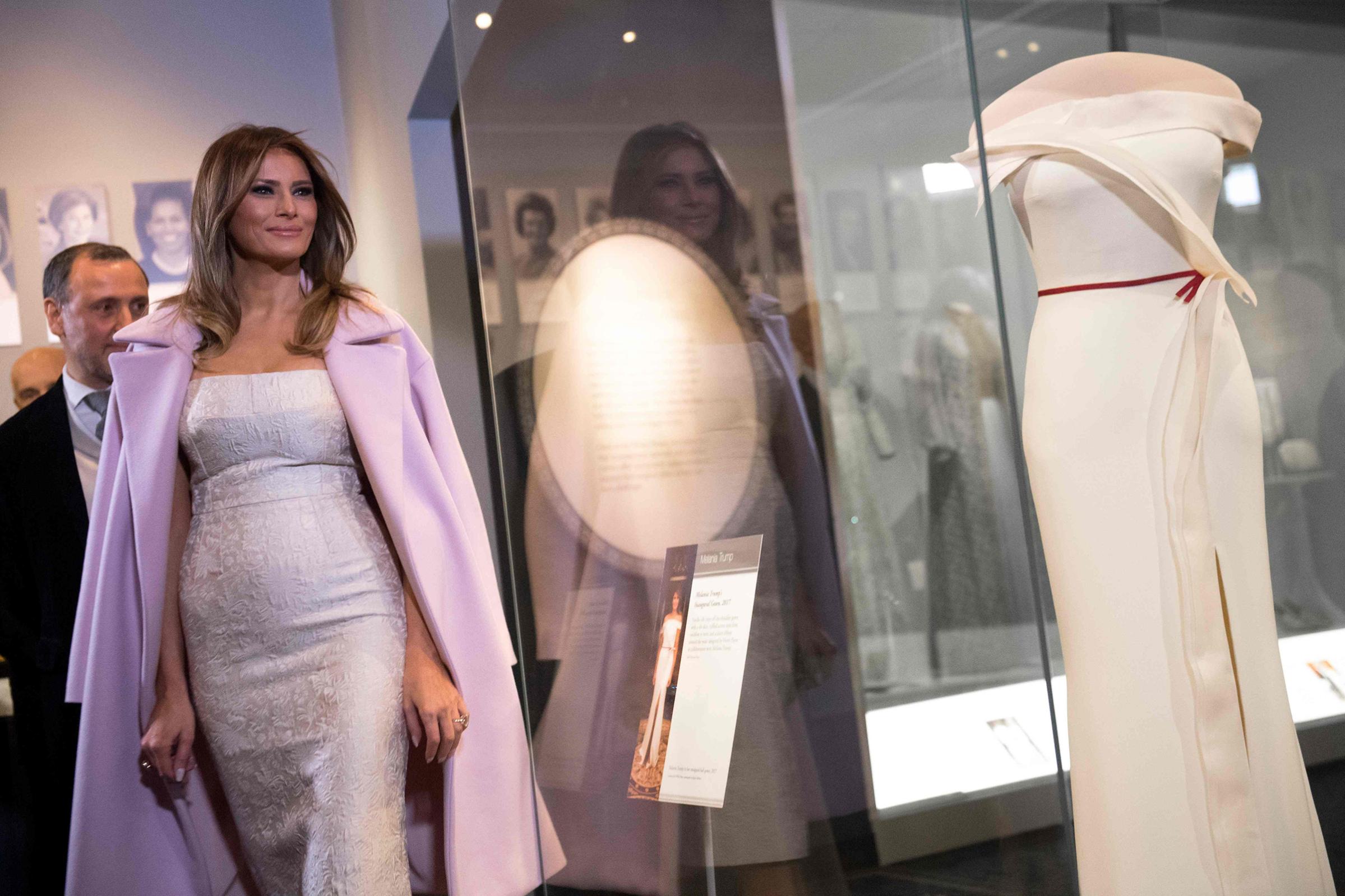 First lady Melania Trump wearing an ivory Dolce &amp; Gabbana dress stands next to Hervé Pierre and his gown, she wore to the 2017 inaugural balls as she donates the dress to the Smithsonian's First Ladies Collection at the Smithsonian National Museum of American History in Washington, DC, Oct. 20, 2017.