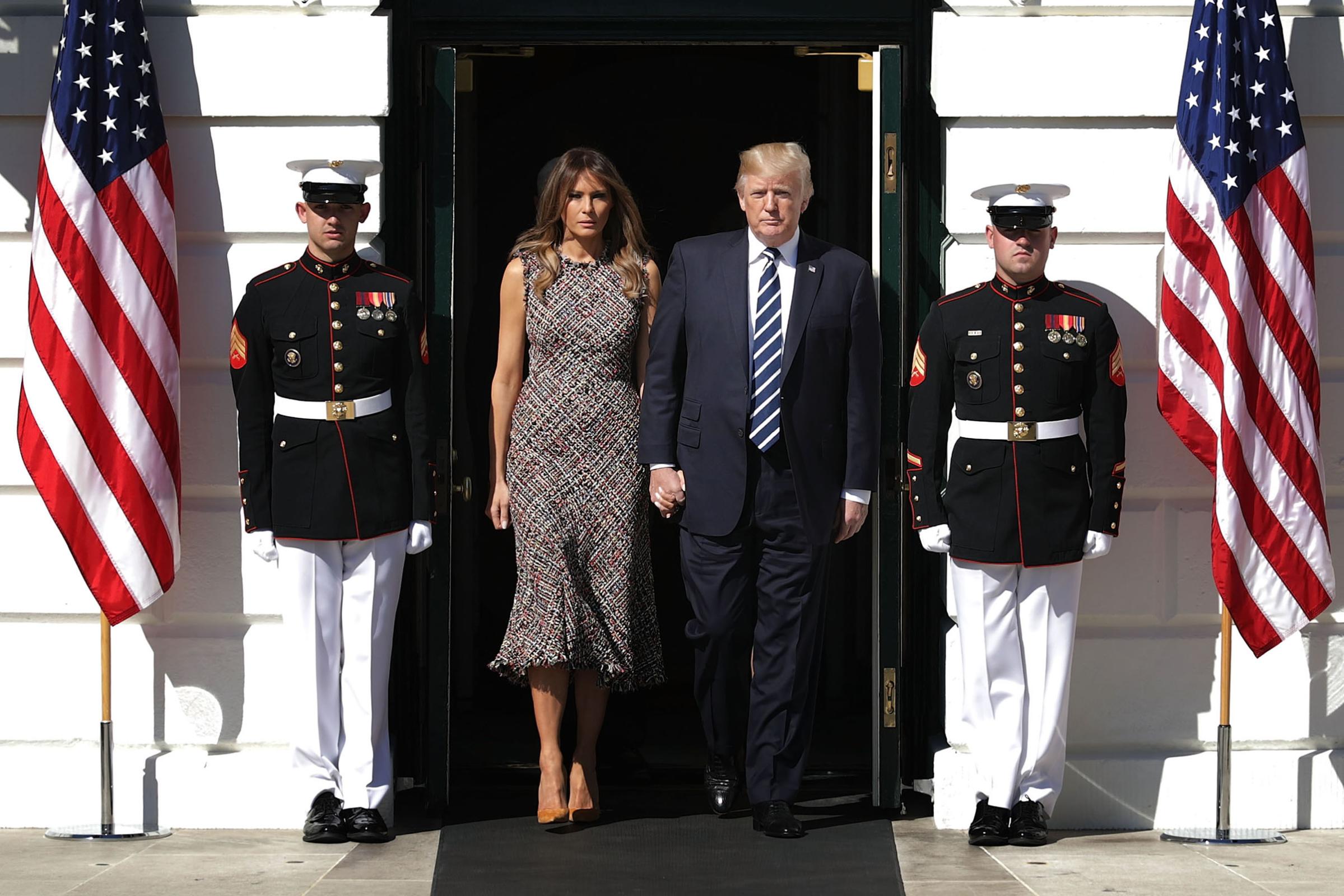 President Donald Trump (R) and first lady Melania Trump wearing a tweed midi dress, walk out of the White House before observing a moment of silence on the South Lawn October 2, 2017 in Washington, DC.