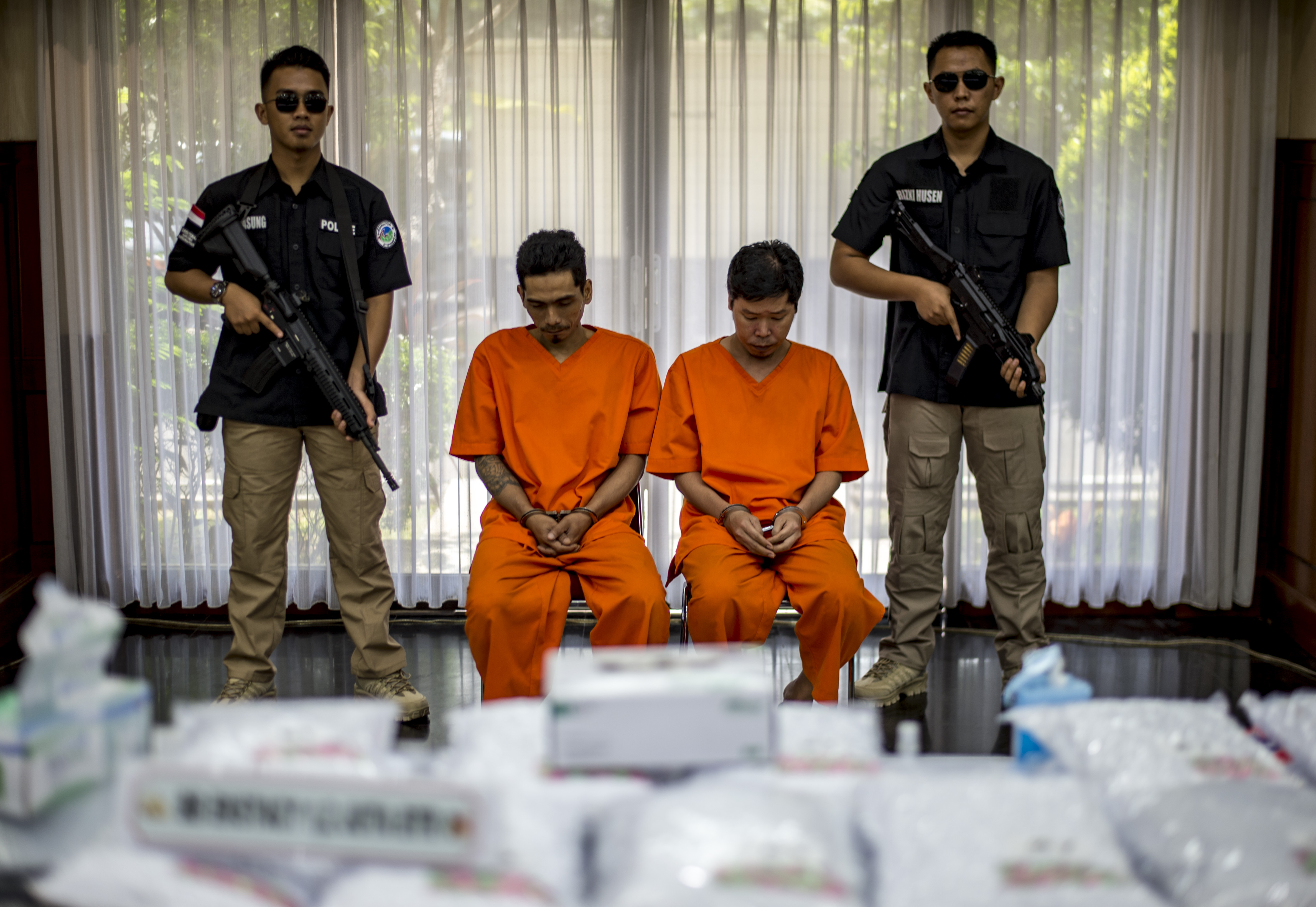 Indonesian narcotics police guard two suspects during a press conference in Jakarta on August 1, 2017. (Bay Ismoyo—AFP/Getty Images)