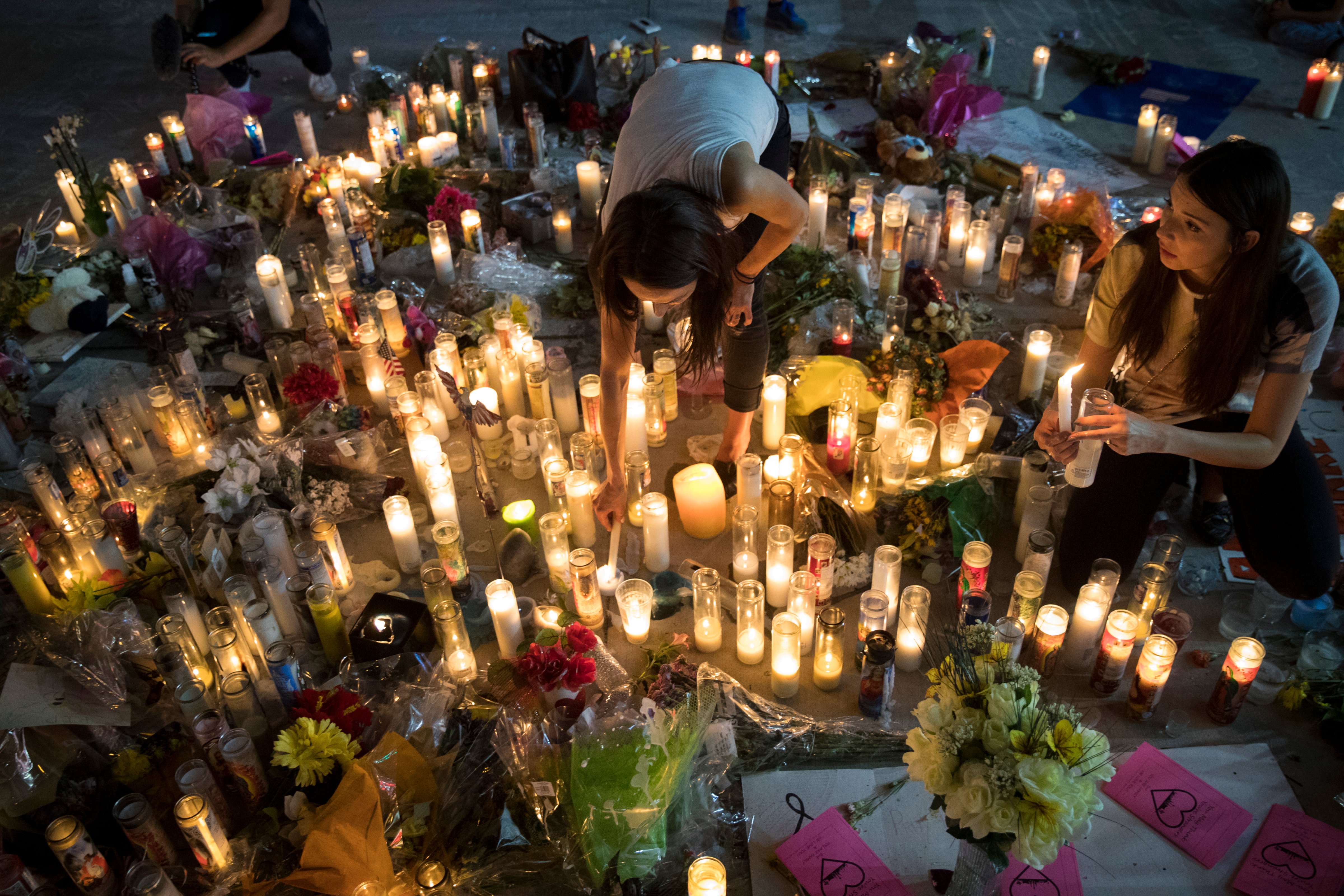 Las Vegas residents Elisabeth Apcar and Dashenka Giraldo light candles at a the makeshift memorial at the northern end of the Last Vegas Strip, October 4, 2017 in Las Vegas, Nevada. (Drew Angerer—Getty Images)