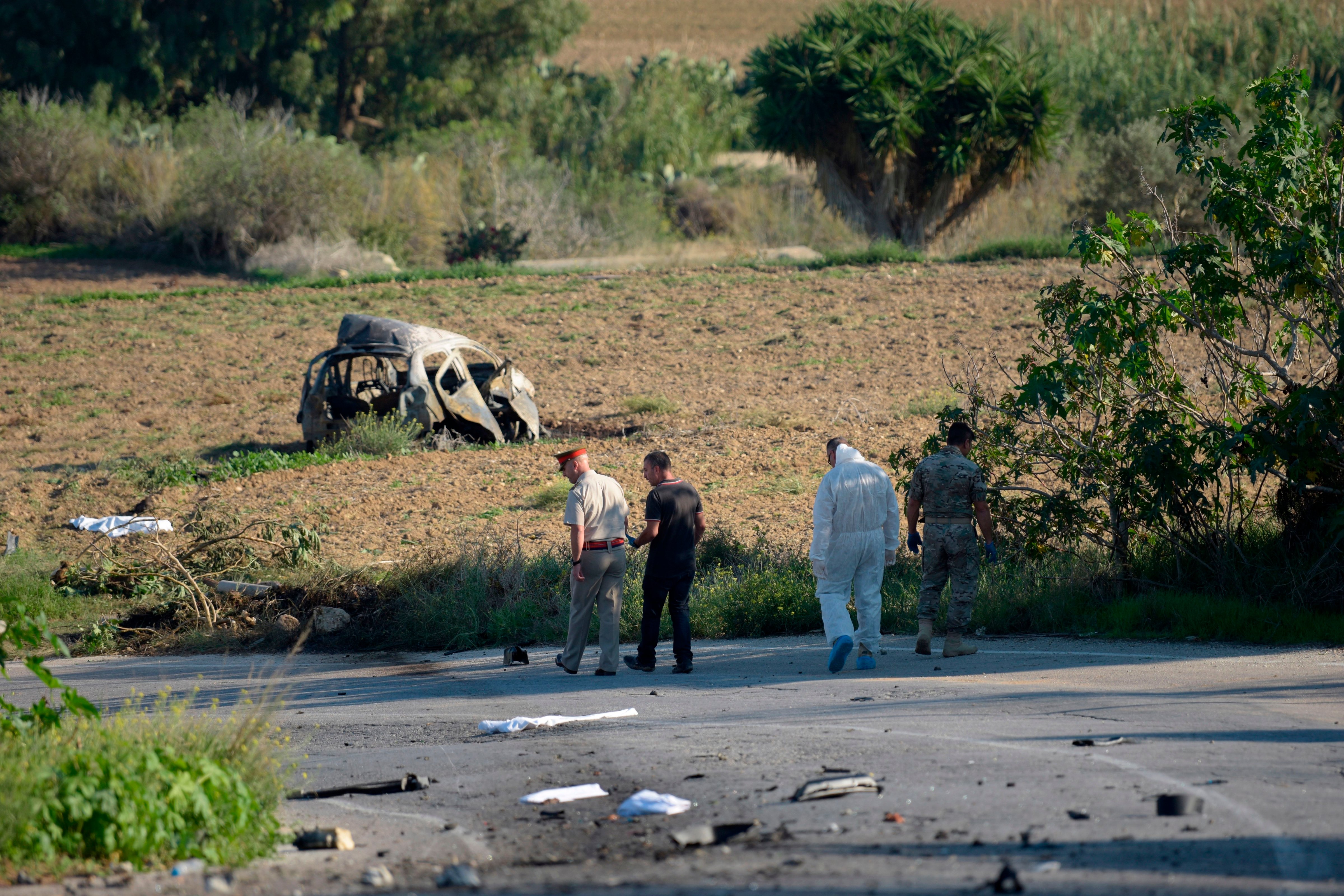Police and forensic experts inspect the wreckage of a car bomb believed to have killed journalist and blogger Daphne Caruana Galizia close to her home in Bidnija, Malta, on October 16, 2017. (AFP/Getty Images)