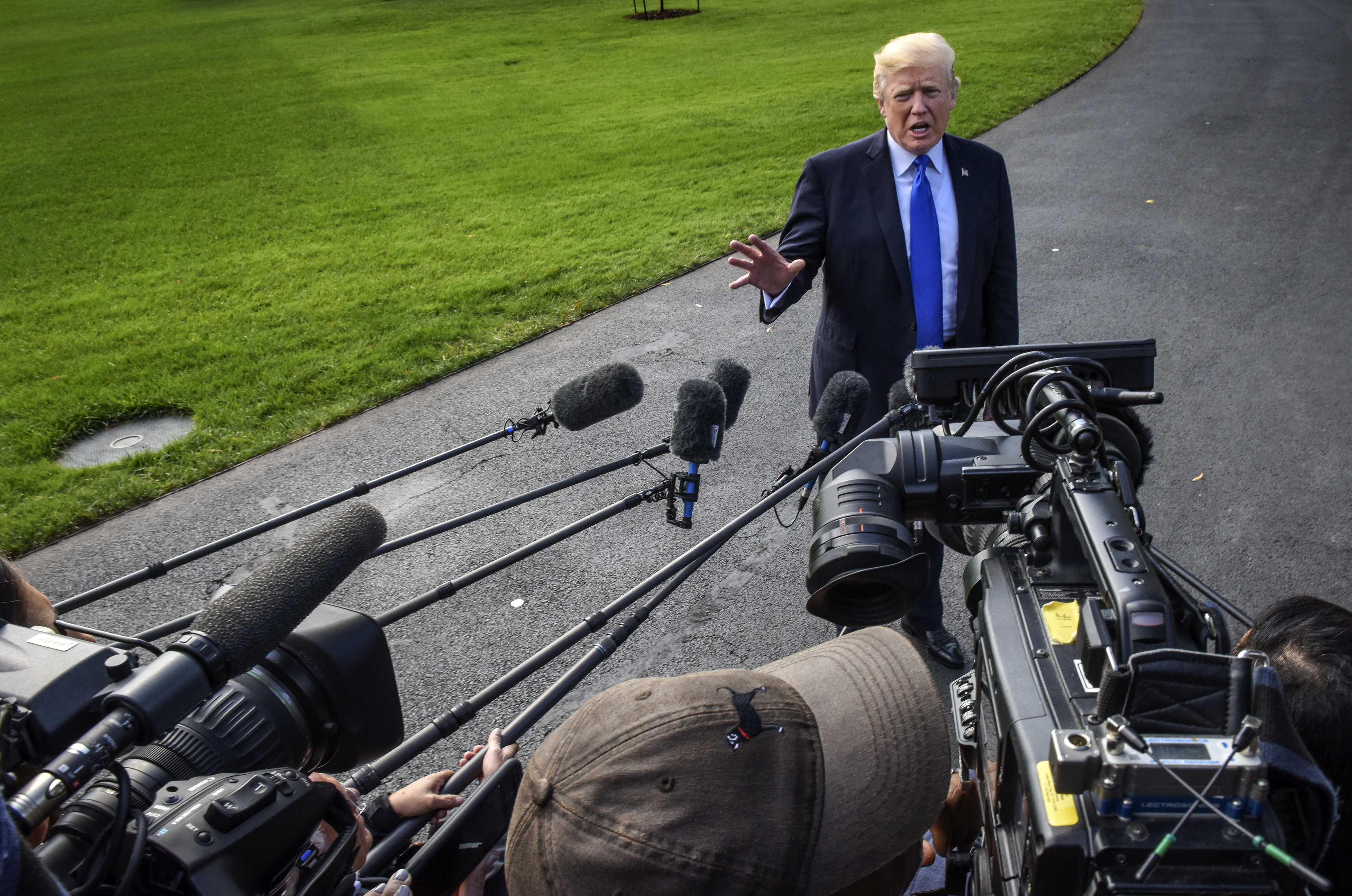 President Donald Trump takes questions from reporters on the way to Marine One before departing for Texas to attend a briefing on hurricane relief efforts on October, 25, 2017 in Washington, DC. (Photo by Bill O'Leary—The Washington Post/Getty)