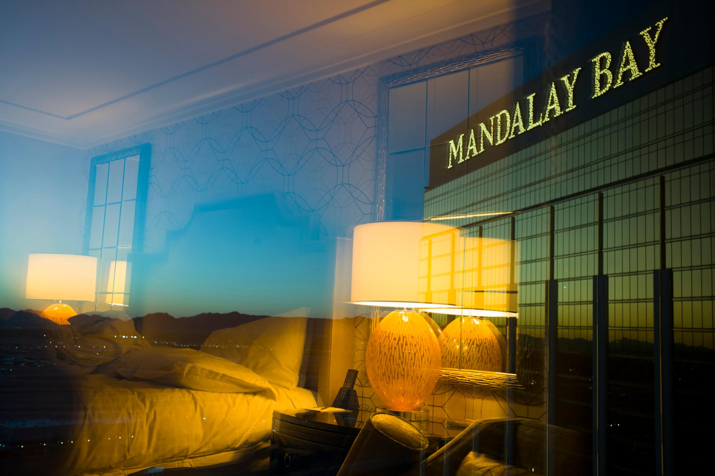 Photographer's hotel room is reflected on to the window that he is shooting through, on the other side of the glass is the Mandalay Bay Hotel sign, Oct. 3, 2017.