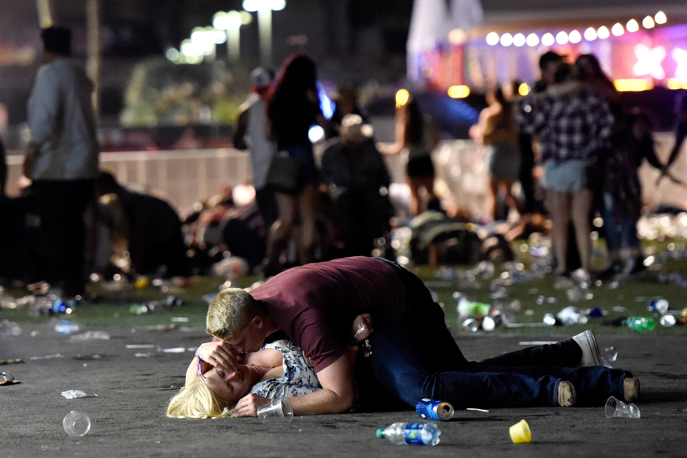 A man lays on top of a woman as others flee the Route 91 Harvest country music festival grounds after a active shooter was reported at Mandalay Bay on Oct. 1, 2017 in Las Vegas. (David Becker/Getty Images)