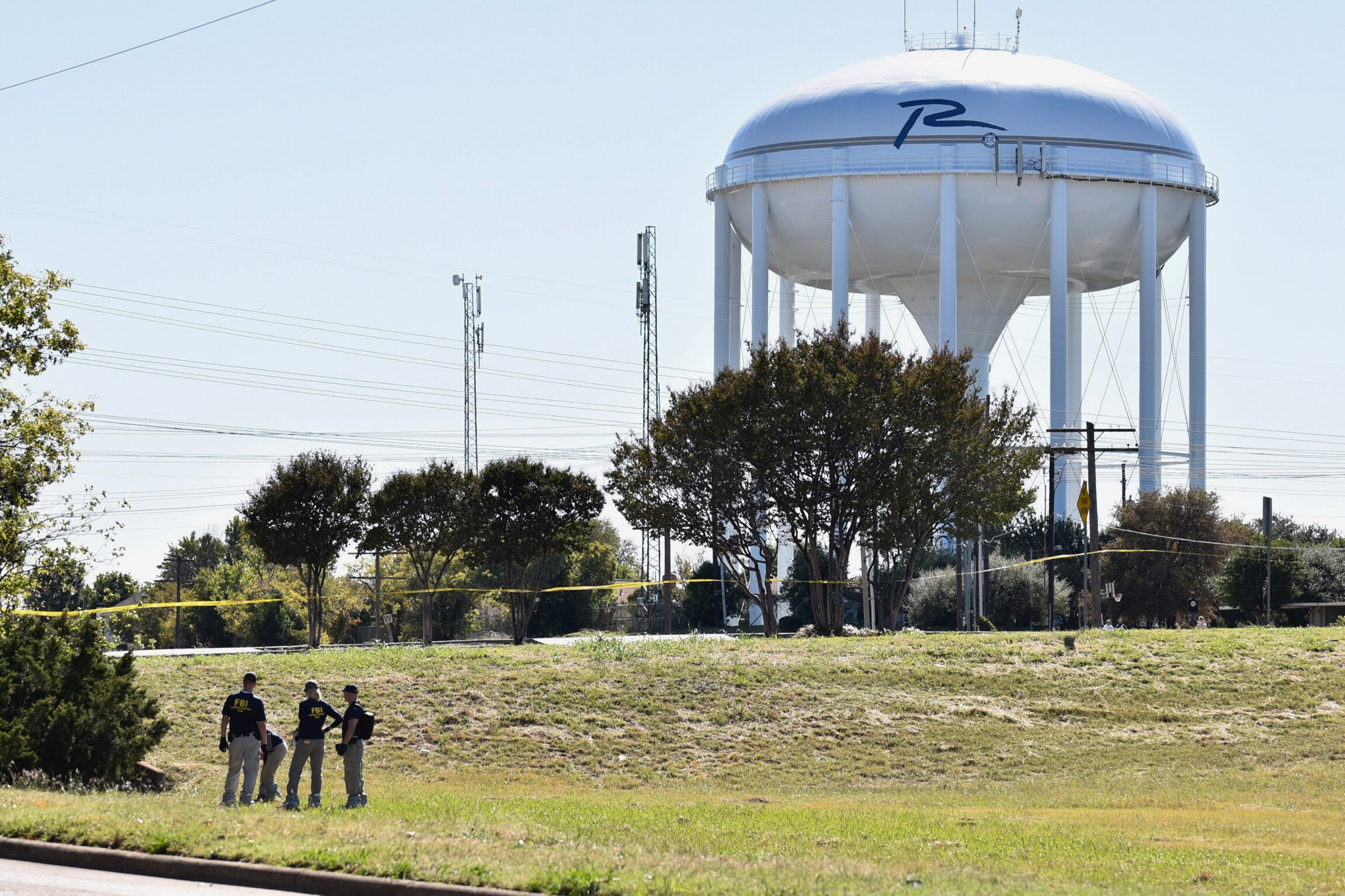 FBI investigators search a grassy area near a ditch where a child's body was found, as the search continued for a missing girl in Richardson, Texas, on Oct. 22, 2017. (Ben Torres—The Dallas Morning News/AP)