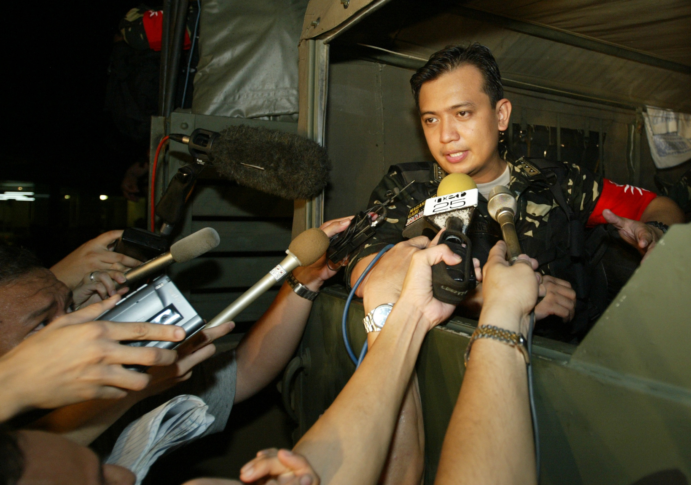 Navy Lieutenant Antonio Trillanes, then a mutiny leader, speaks to journalists after the end of a seige of a Manila shopping centre July 27, 2003. (Claro Cortes—Reuters)