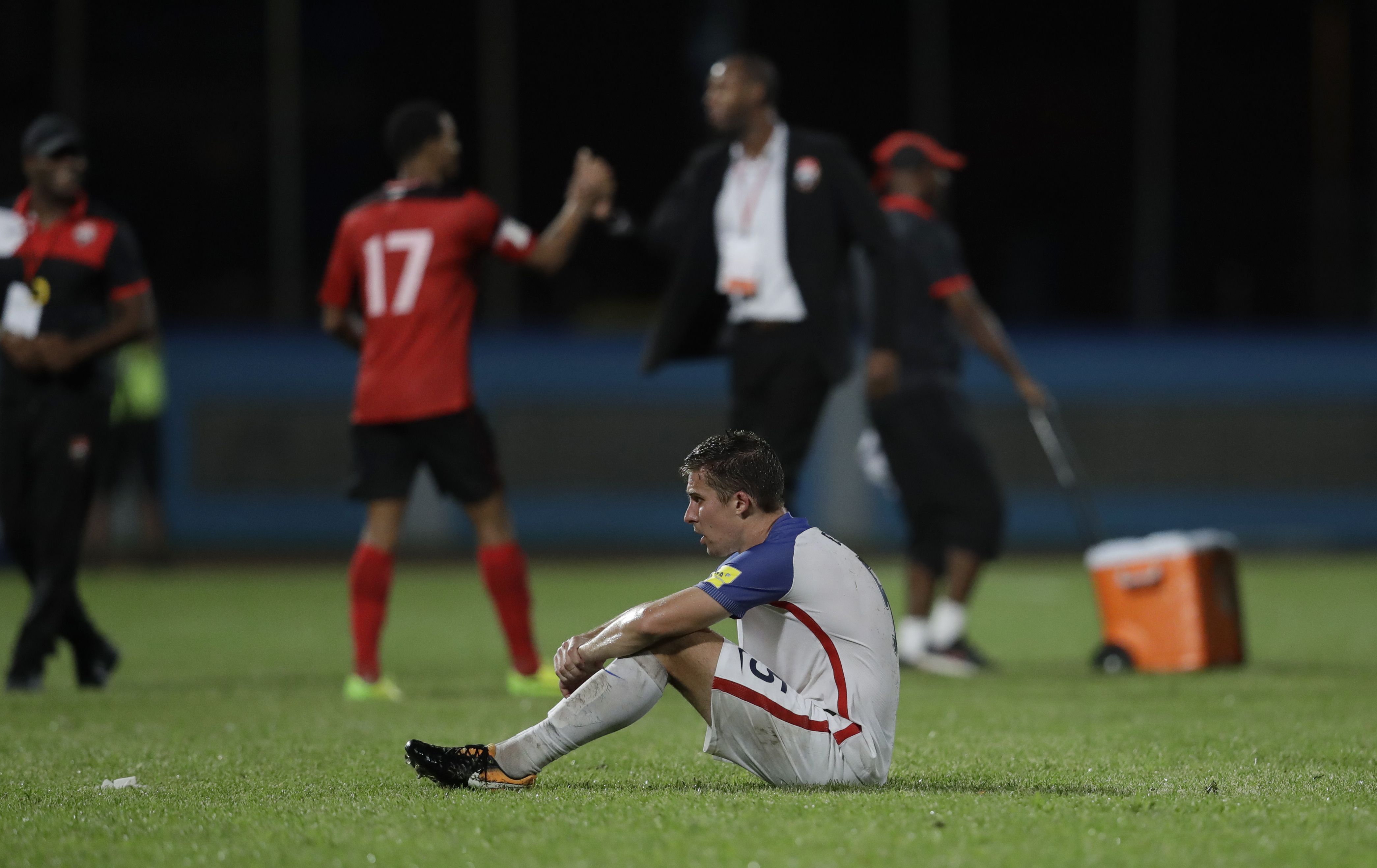 USMNT's Matt Besler squats on the pitch after losing 2-1 against Trinidad and Tobago during a 2018 World Cup qualifying soccer match in Couva, Trinidad, on Oct. 10, 2017. (Rebecca Blackwell—AP)