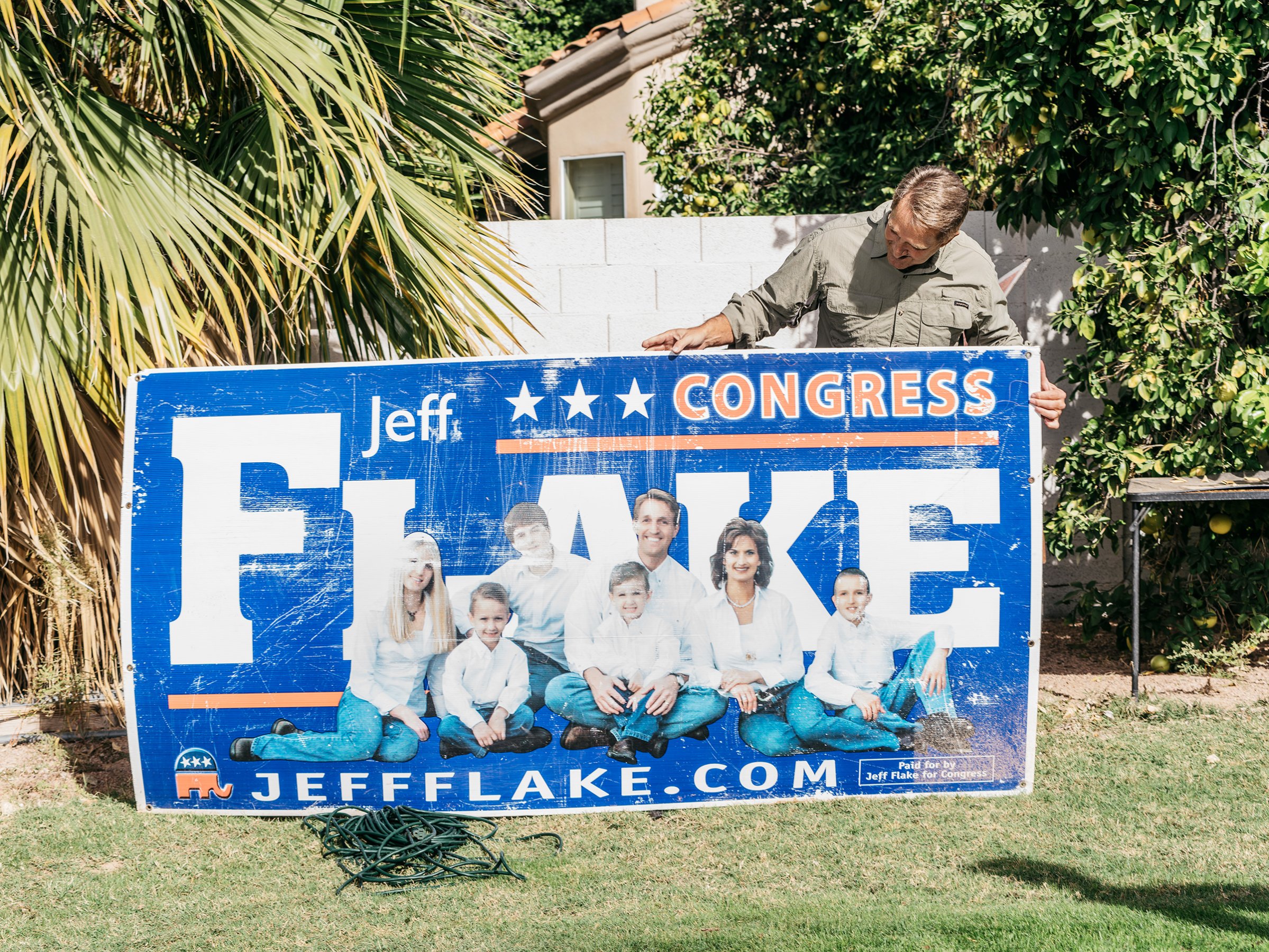 Jess Flake holds an old campaign sign in his backyard, Mesa, Ariz.