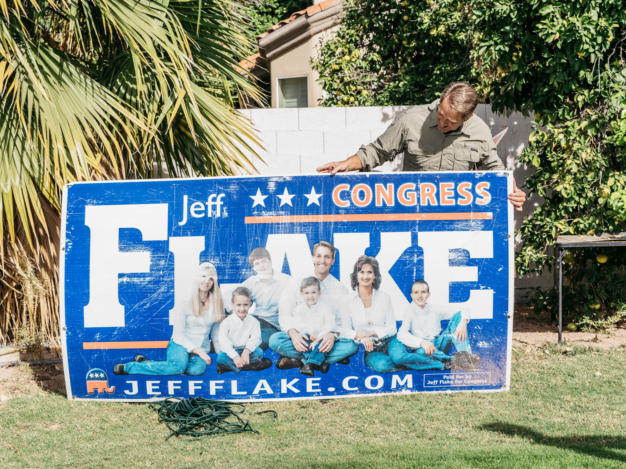 Flake holds an old campaign sign in his backyard, Mesa, Ariz. (Michael Friberg for TIME)