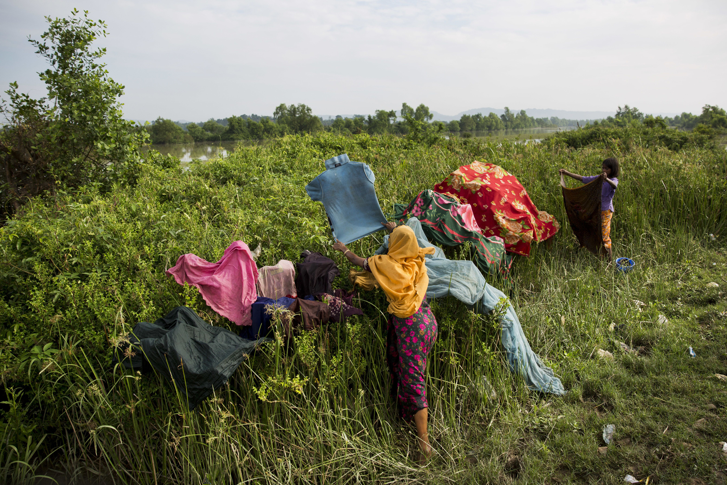 Rohingya dry their clothes as they wait along the border after crossing the Naf River near Palong Khali, Bangladesh, on Nov. 2, 2017. (Bernat Armangue—AP)