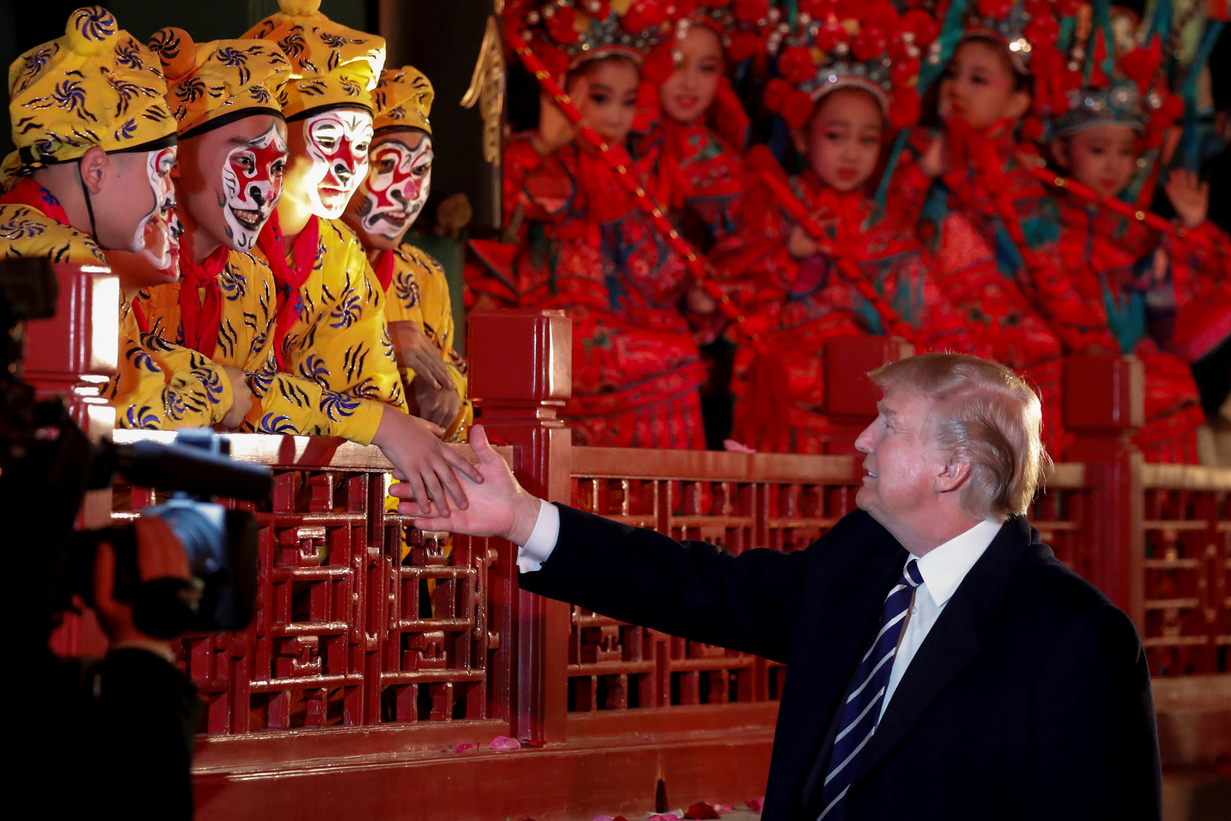 U.S. President Donald Trump shakes hands with opera performers at the Forbidden City in Beijing