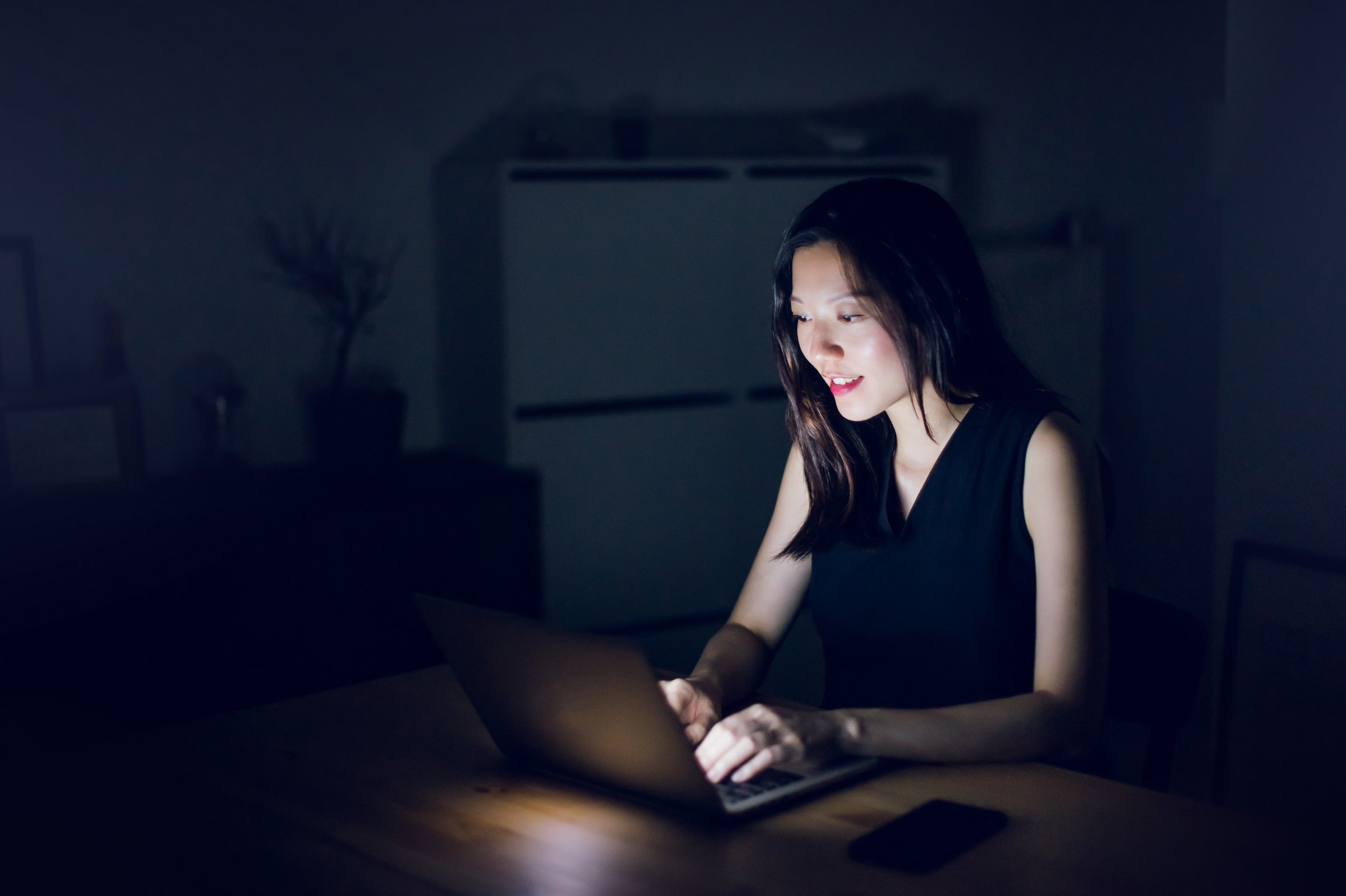 Young businesswoman working late at computer in home office