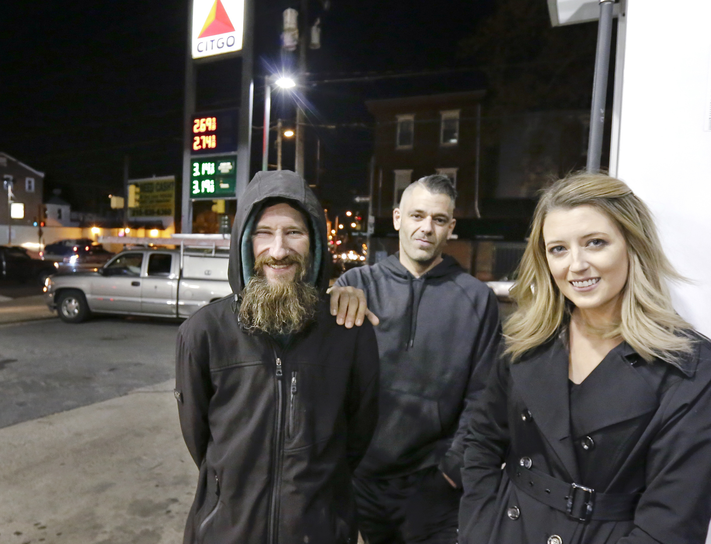 Johnny Bobbitt Jr., left, Kate McClure, right, and McClure's boyfriend Mark D'Amico pose at a Citgo station in Philadelphia. (Elizabeth Robertson&mdash;The Philadelphia Inquirer/AP)