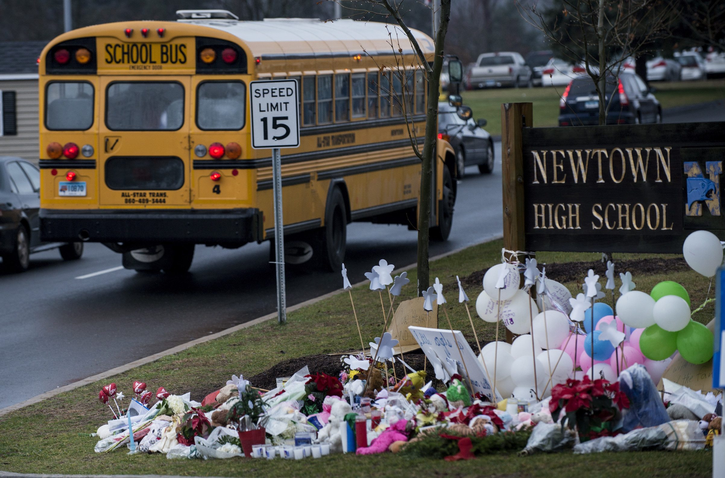 A school bus passes a makeshift memorial to the victims of the Sandy Hook Elementary School shooting as it takes students to Newtown High School Dec. 18, 2012 in Newtown, Conn. (Brendan Smialowski--AFP/Getty Images)