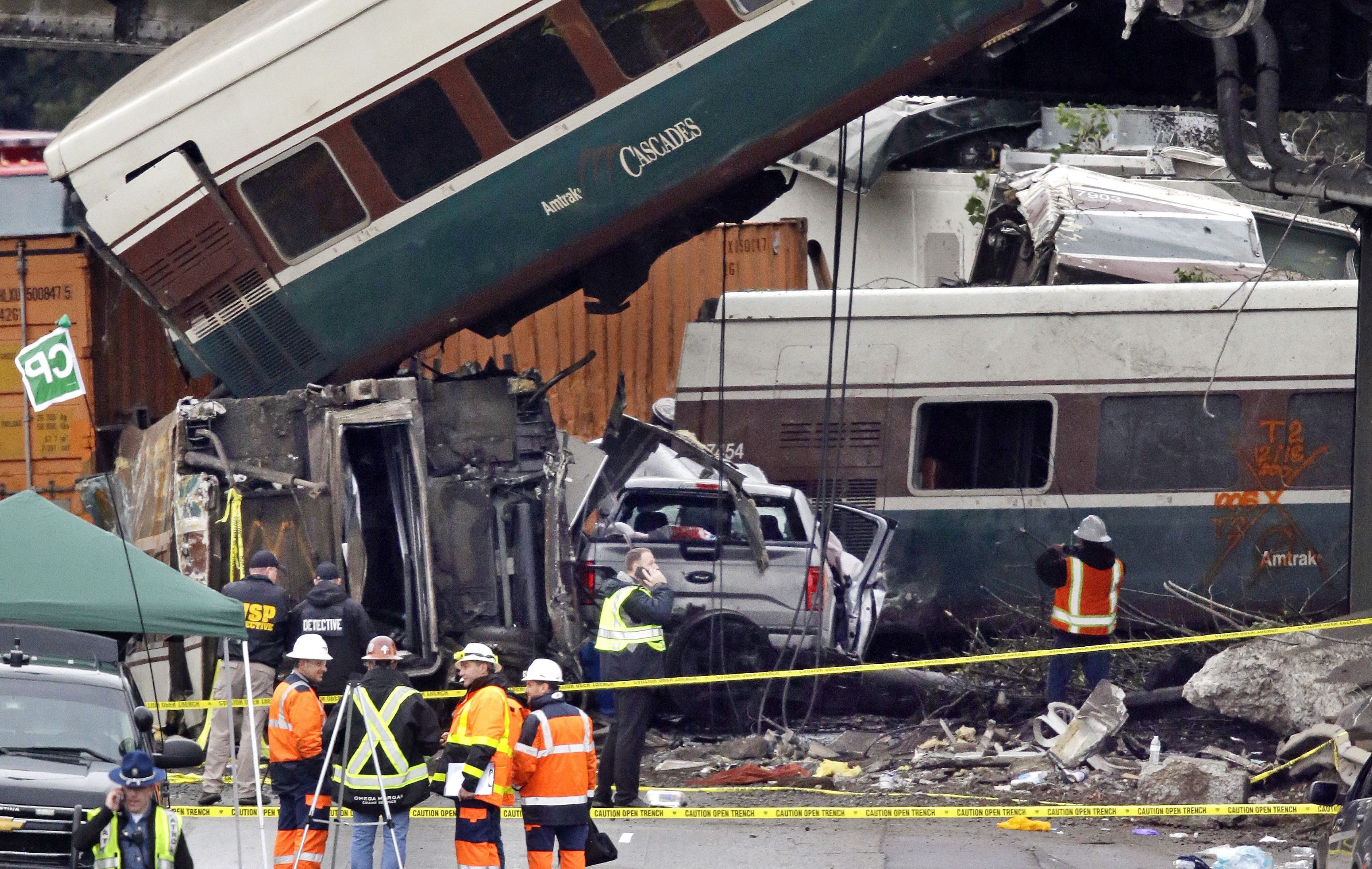 Cars from an Amtrak train that derailed above lay spilled onto Interstate 5 alongside smashed vehicles, in DuPont, Wash. The Amtrak train making the first-ever run along a faster new route hurtled off the overpass Monday near Tacoma and spilled some of its cars onto the highway below, killing some people, authorities said — Shutterstock/AP (Elaine Thompson/AP/REX/Shutterstock&mdash;Thompson/AP/REX/Shutterstock)