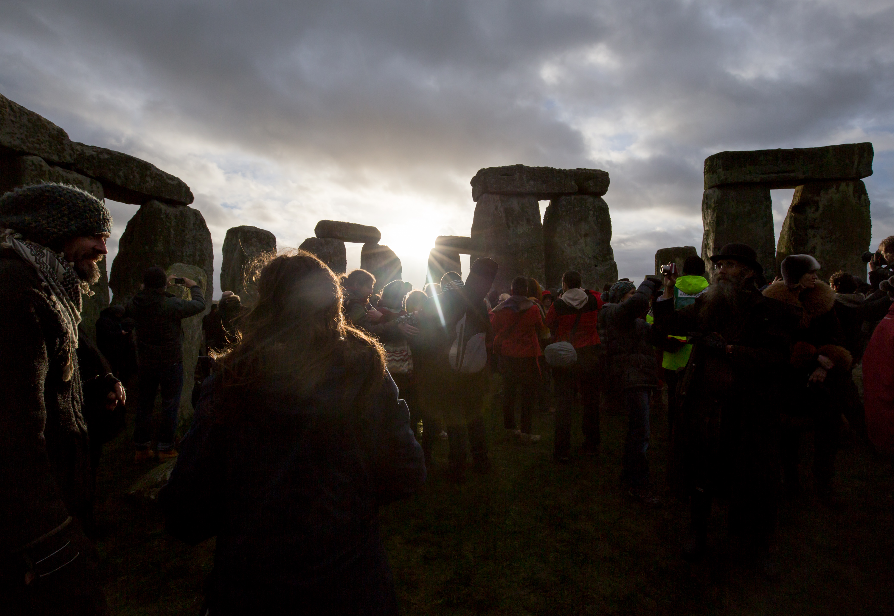 The sun makes a brief appearance through clouds as druids, pagans and revelers gather in the centre of Stonehenge in Wiltshire, England for the 2015 winter solstice. (Matt Cardy—Getty Images)