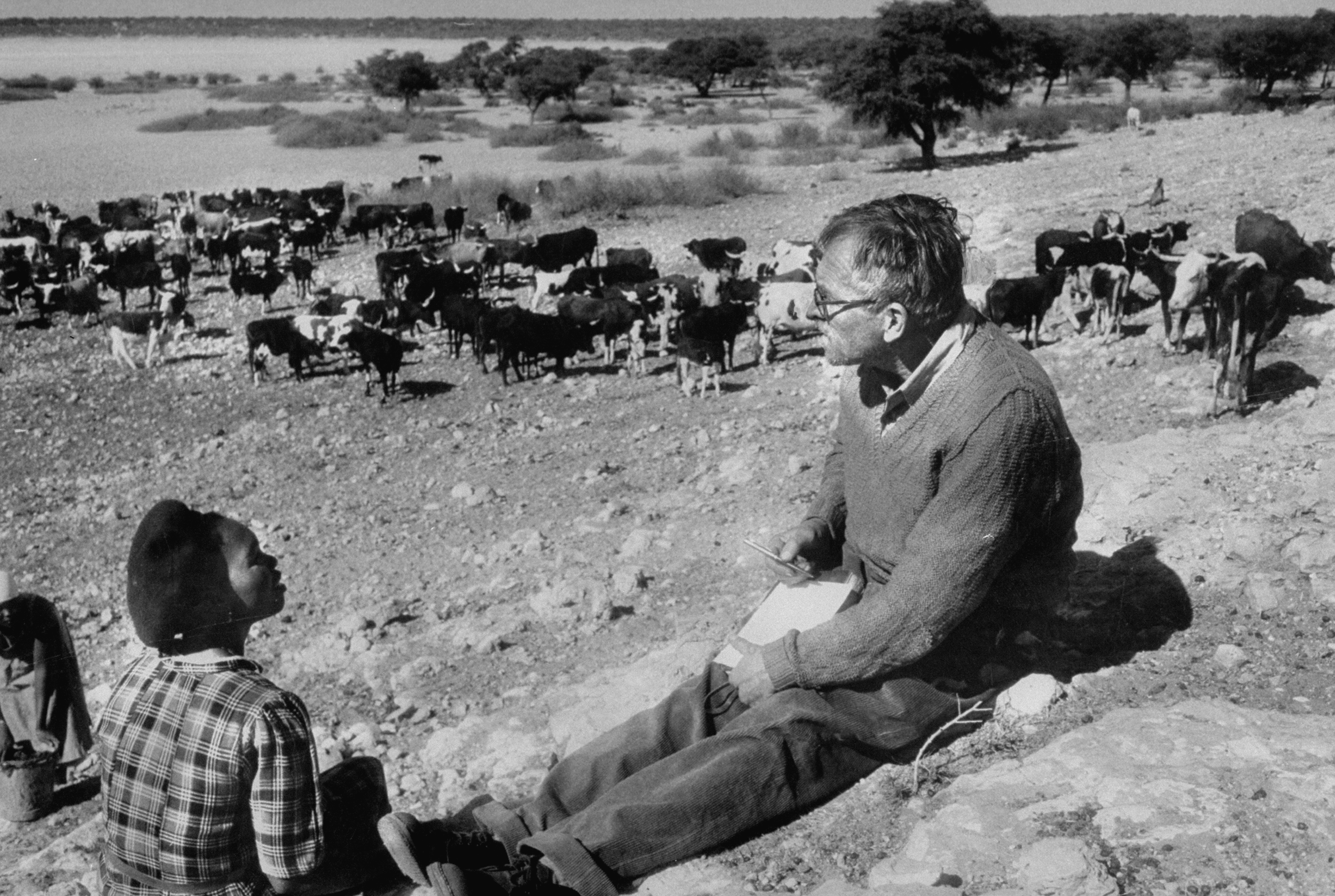 Author, Alan Paton (R) interviewing Herrero woman, Katrina Whiteman against the backdrop of the Tshani well during during his Kalahari expedition in Bechuanaland. (Terence Spencer—The LIFE Images Collection/Getty Images)
