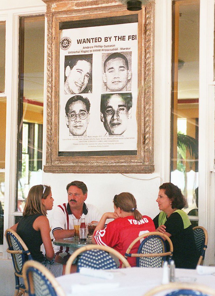 Diners at the Edgewater Hotel on Miami Beach sit under a large wanted poster of Andrew Cunanan in July 1997 (ROBERT SULLIVAN - AFP/Getty Images)