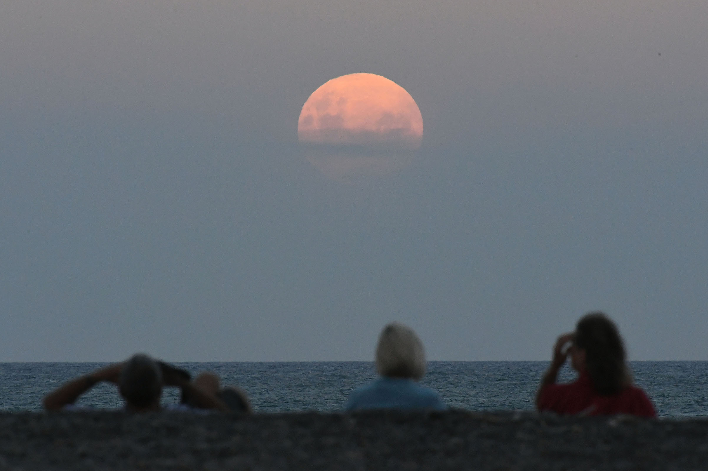 Crowds gather on the Marine Parade Beach to watch the Super Blue Blood Moon rise in Napier, New Zealand on Jan. 31, 2018. (Kerry Marshall—Getty Images)