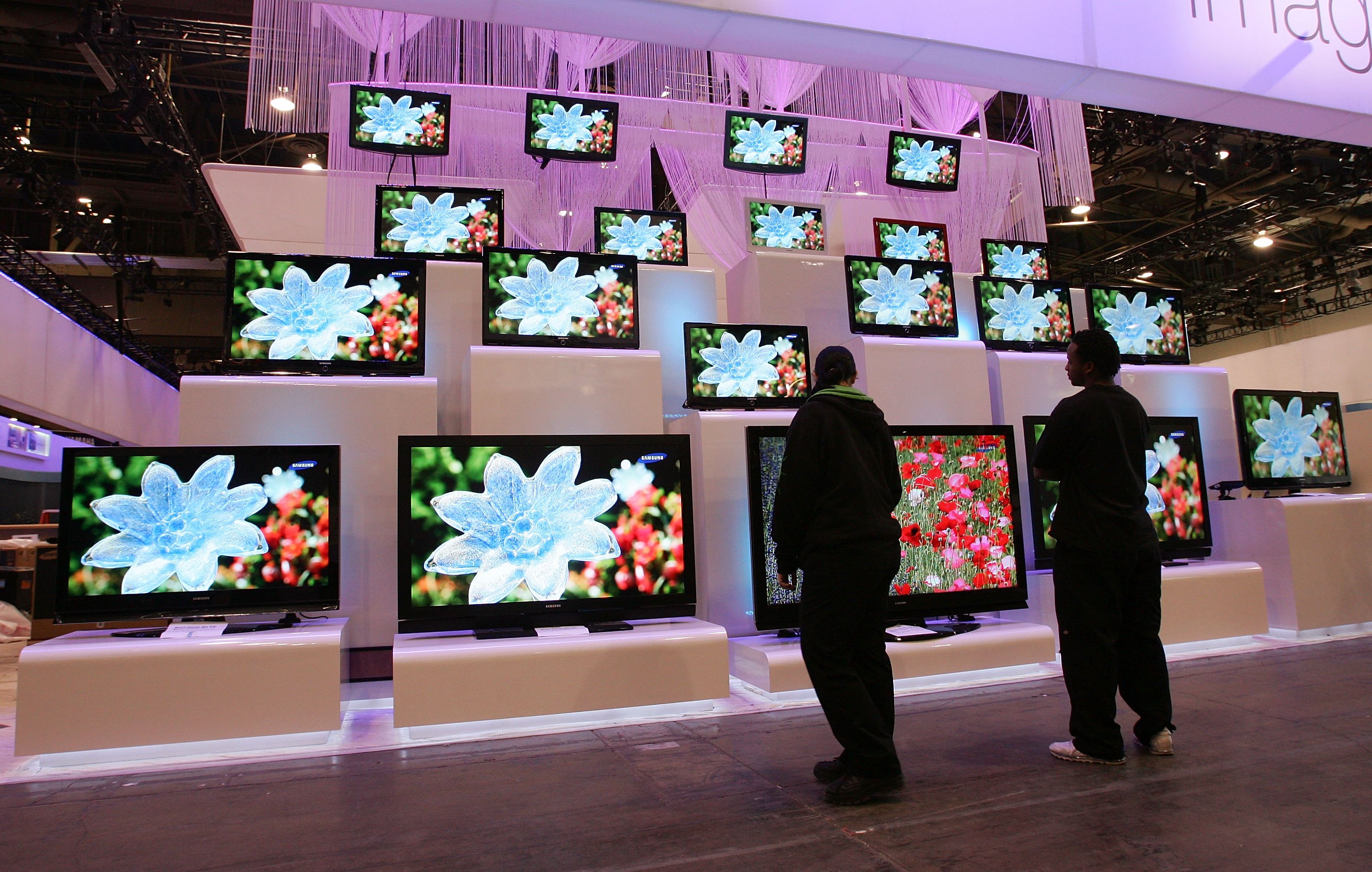 Workers look at a display of televisions by Samsung at the Las Vegas Convention Center as preparations continue for the opening of the 2007 International Consumer Electronics Show January 5, 2007 in Las Vegas, Nevada. (Ethan Miller—Getty Images)