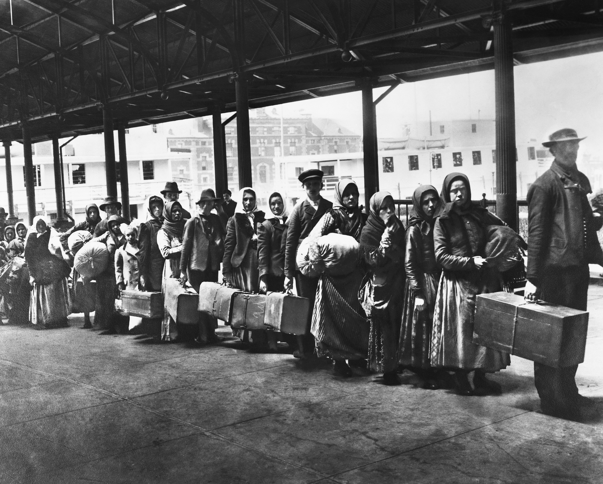 Immigrants on line leaving Ellis Island waiting for ferry to N.Y., ca 1900. (Bettmann / Getty Images)