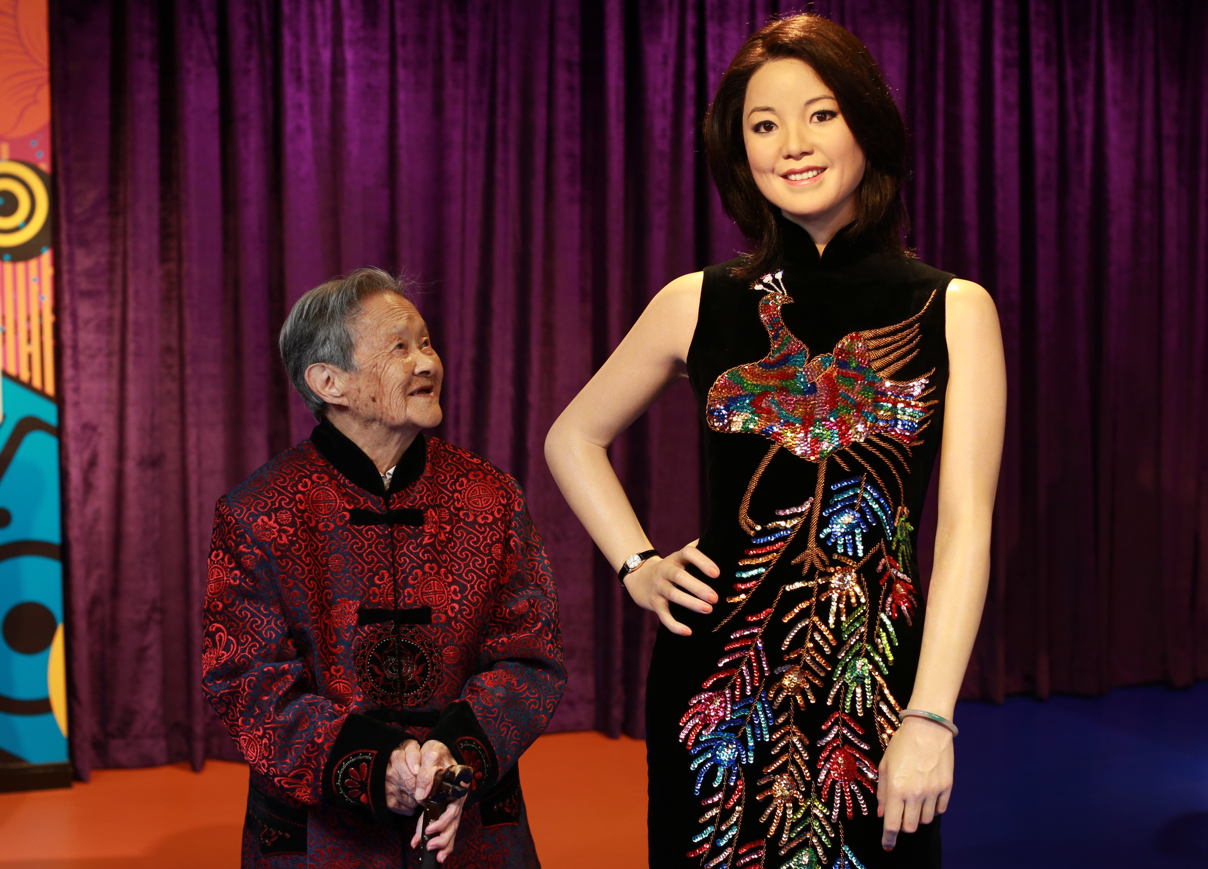 uang Xiaogui, 100 years old, poses with a wax figure of Teresa Teng at Madame Tussauds on in Wuhan, China on Oct. 11, 2013. (VCG—VCG/Getty Images H)