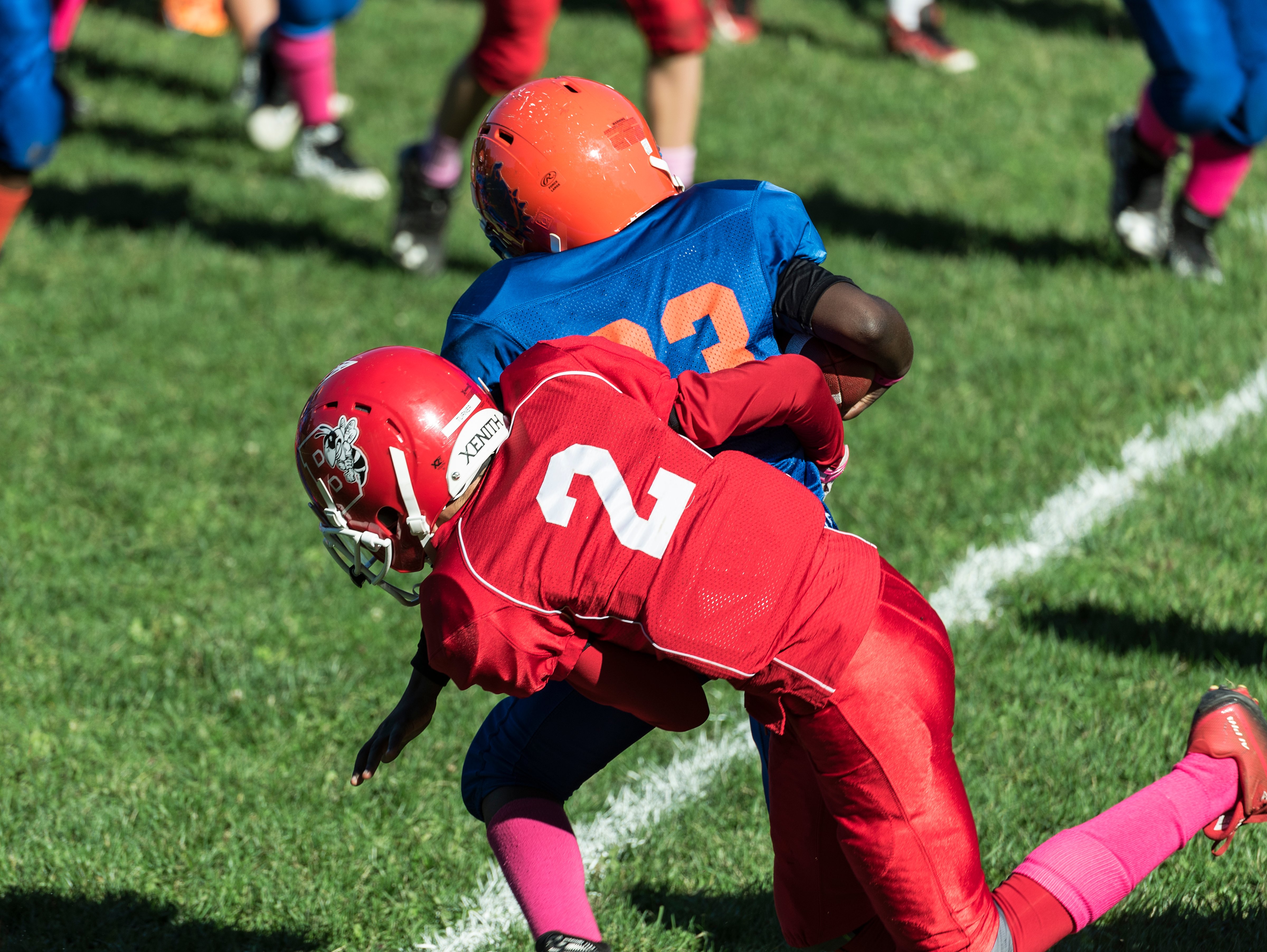 Making a tackle during a Pop Warner football game. (John Greim&mdash;LightRocket via Getty Images)