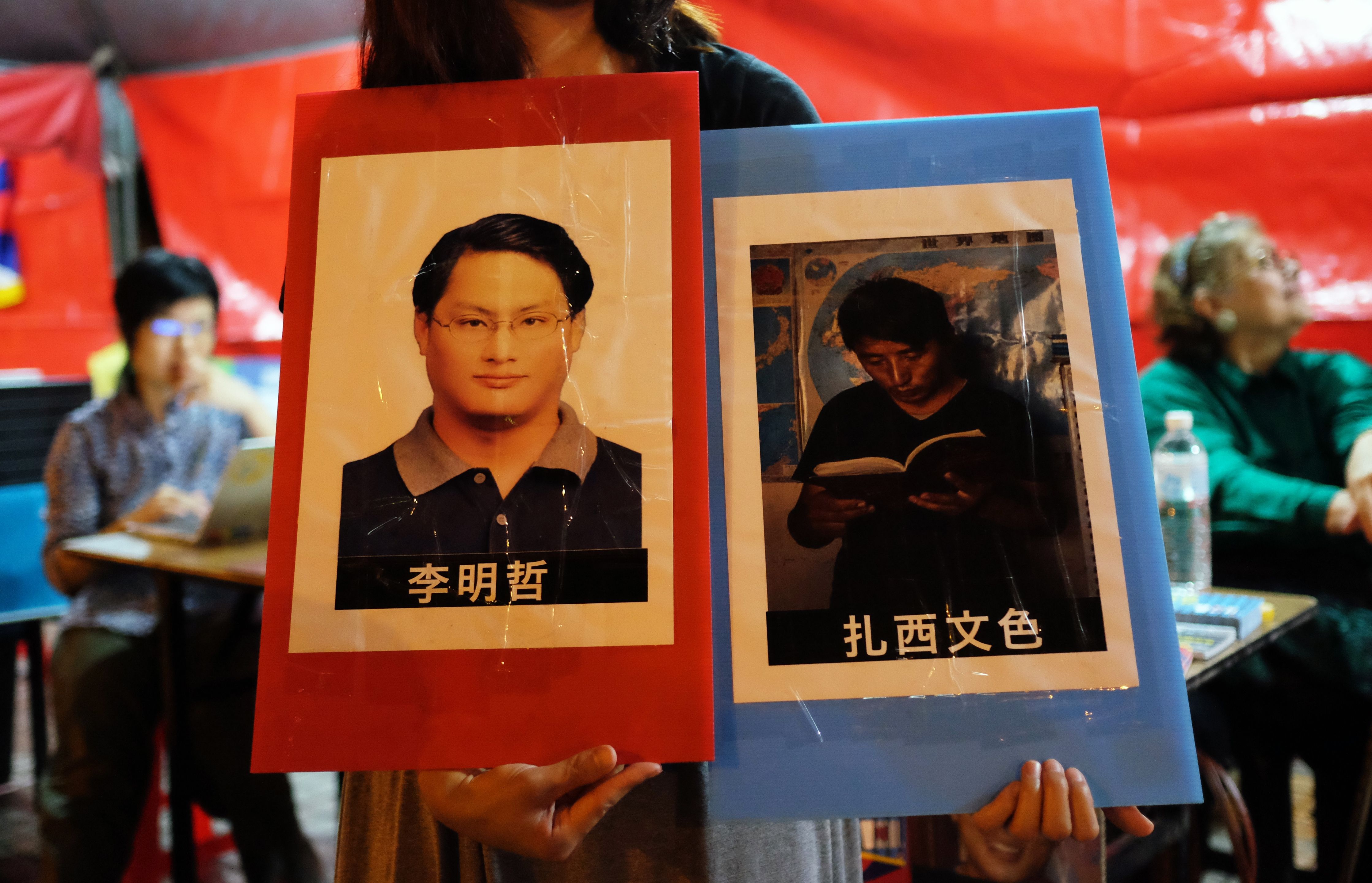 A volunteer holds placards of detained Tibetan activist Tashi Wangchuk and Taiwanese activist Lee Ming-cheh in Taipei, Taiwan on June 4, 2017. (Sam Yeh—AFP/Getty Images)