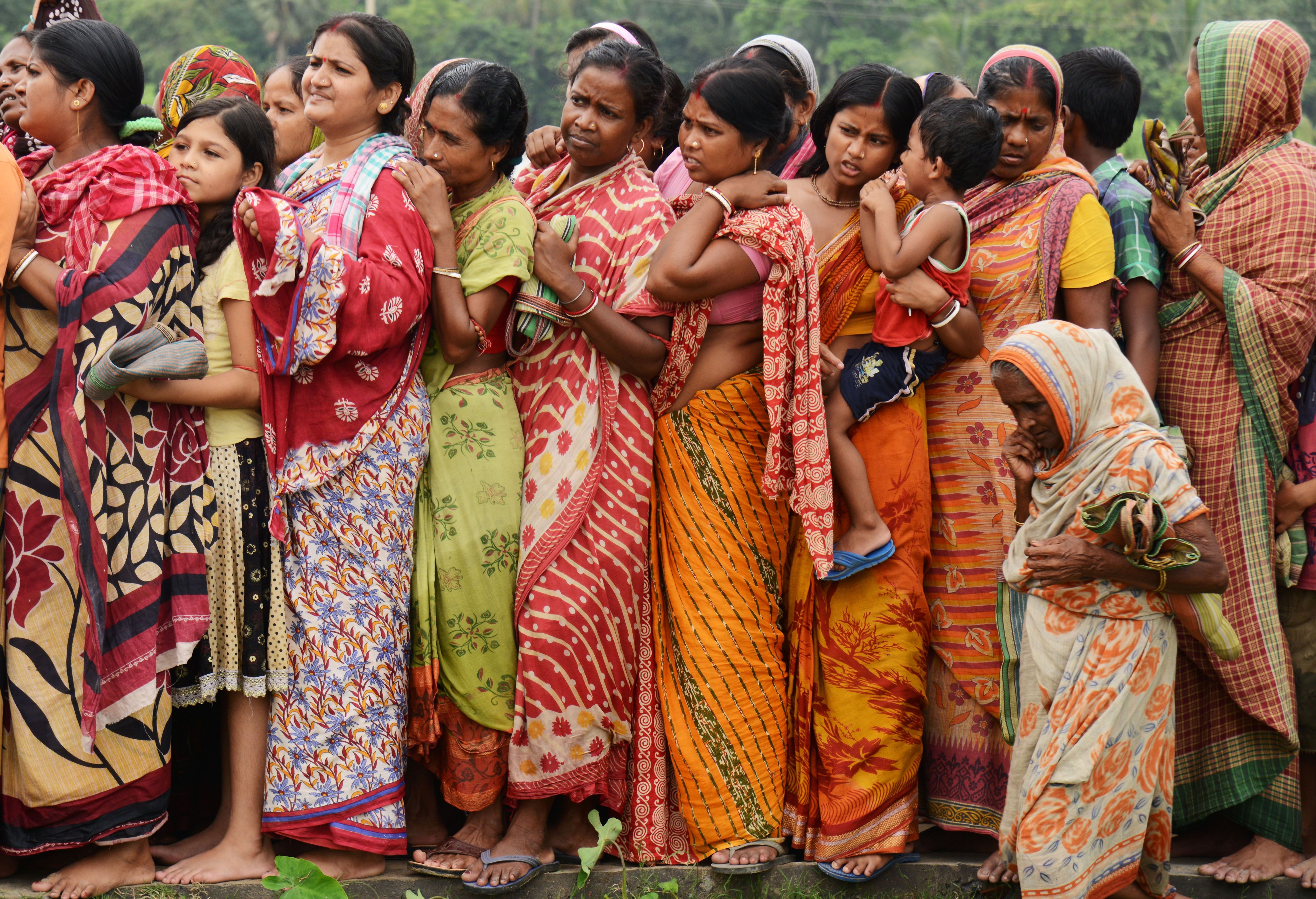 Indian flood victims wait in a queue to collect relief materials in Chitnan village, around 60 km West of Kolkata, on July 28, 2017. (Dibyangshu Sarkar—AFP/Getty Images)